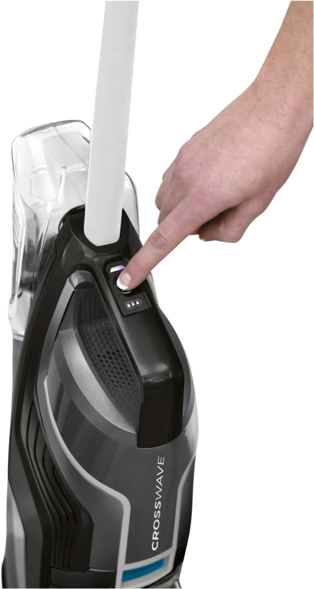 Main d'une personne appuyant sur le bouton d'alimentation d'un aspirateur noir et gris.
