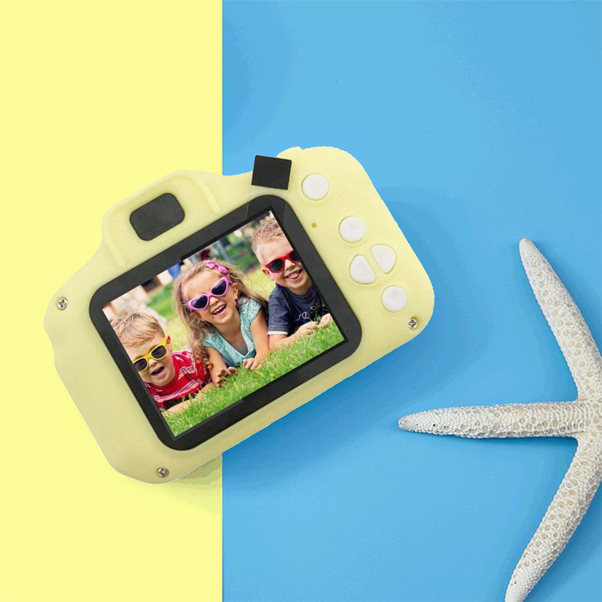 Aparat zabawkowy pokazujący troje uśmiechniętych dzieci i rozgwiazdę na kolorowej powierzchni.