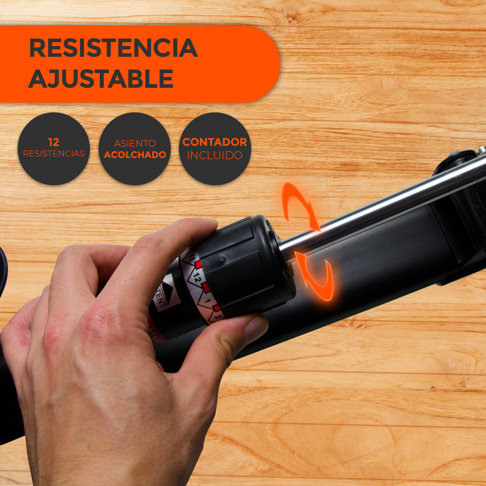 Mano ajustando perilla negra en máquina con ajustes de resistencia. Superficie de madera al fondo.