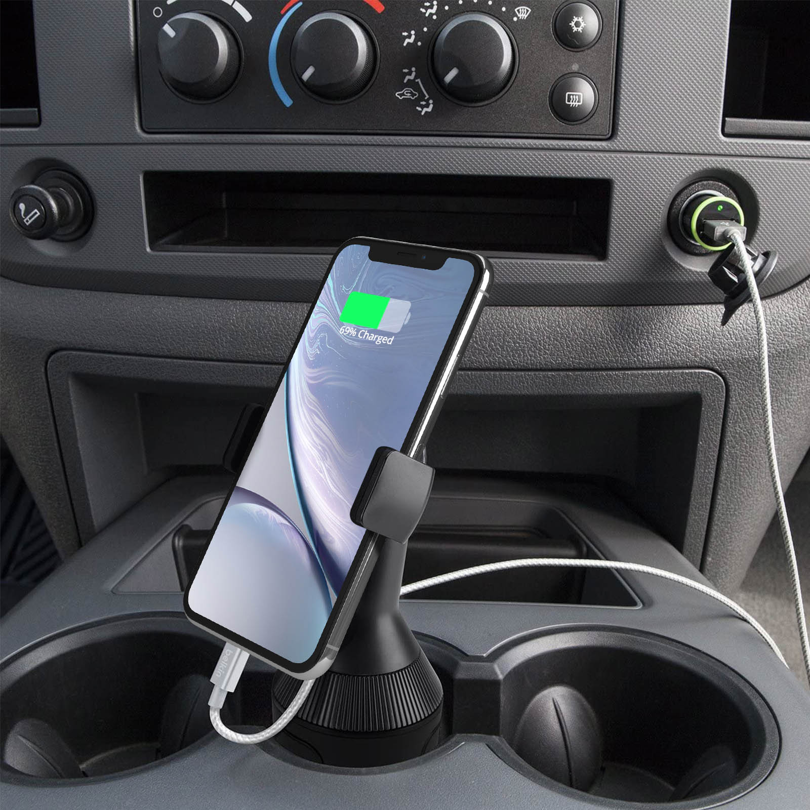 Ein Telefon wird in einem schwarzen Telefonhalter in einem Auto aufgeladen. Das Telefon zeigt 69% geladen.