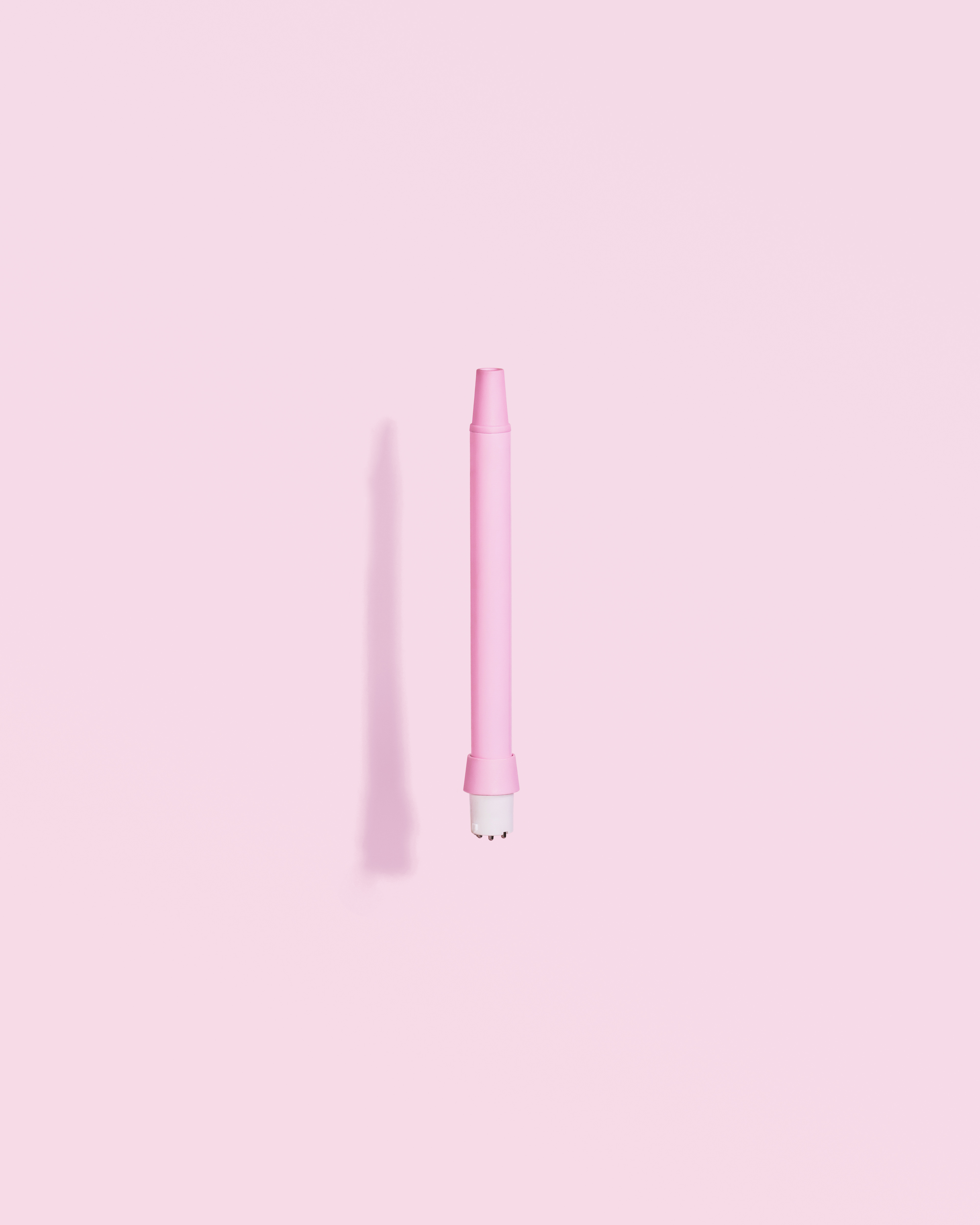 Rosa Vape Pen auf rosa Hintergrund. Ein Schatten wird links unten vom Stift geworfen.
