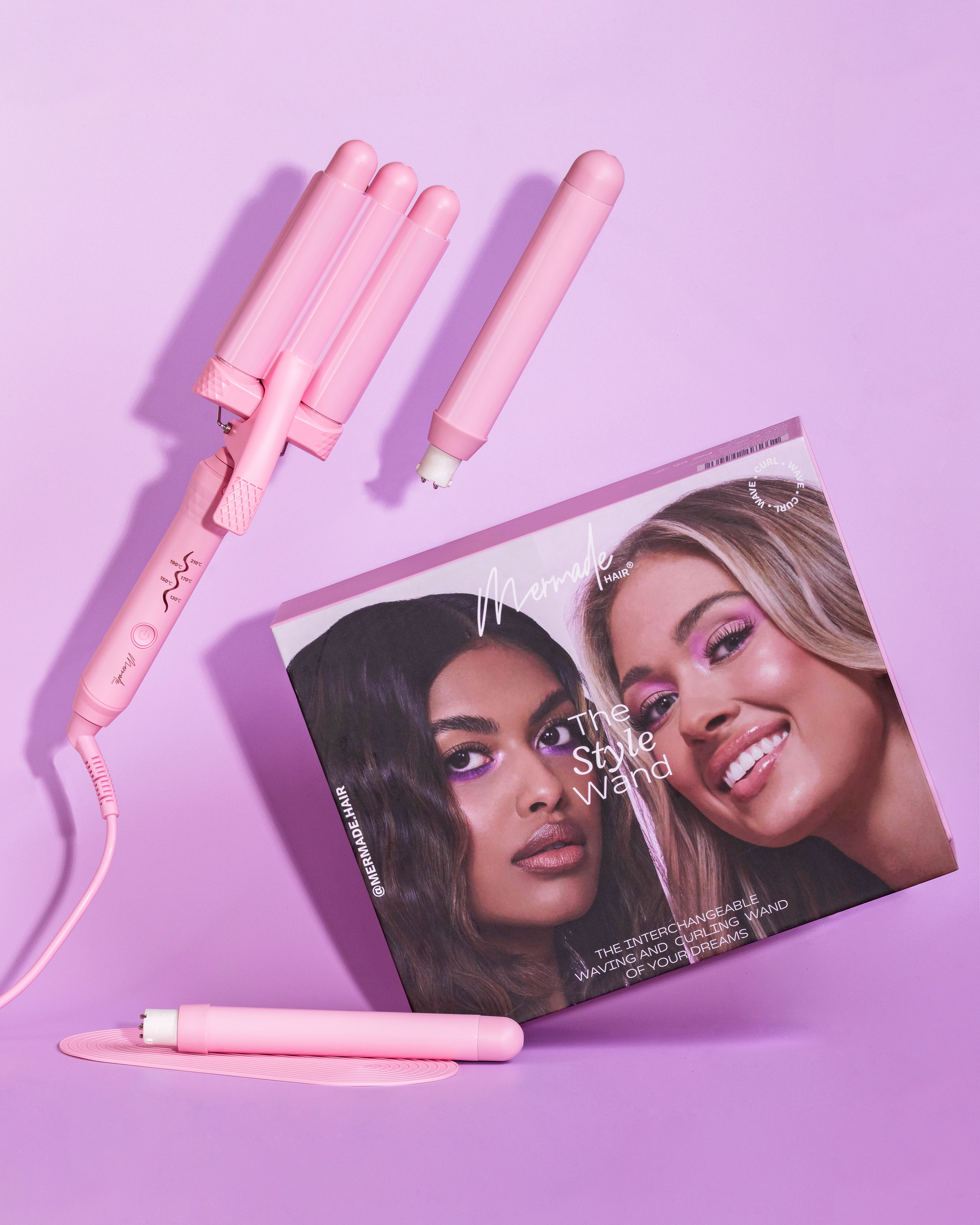 Pinker Haar-Waver, Glätteisen und Box mit zwei Gesichtern von Frauen auf lila Hintergrund.