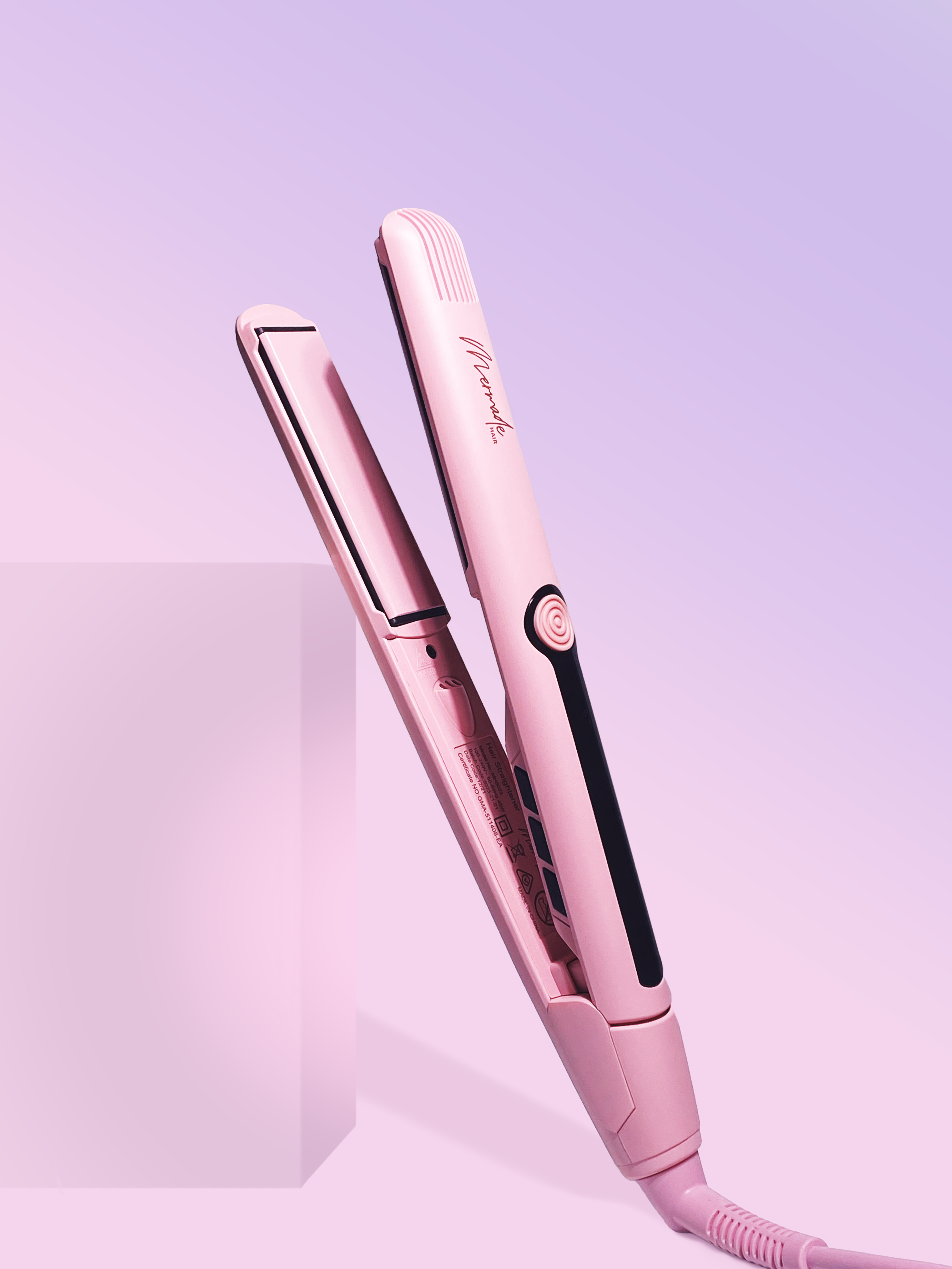 Schräge Ansicht eines geöffneten rosa Glätteisens vor einem abgestuften lila-rosa Hintergrund.