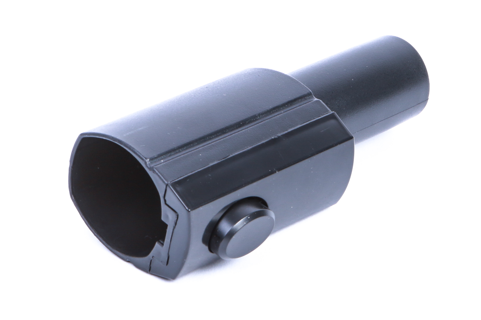 Schwarzer Kunststoffadapter mit Knopf. Schräge Ansicht auf weißer Oberfläche.