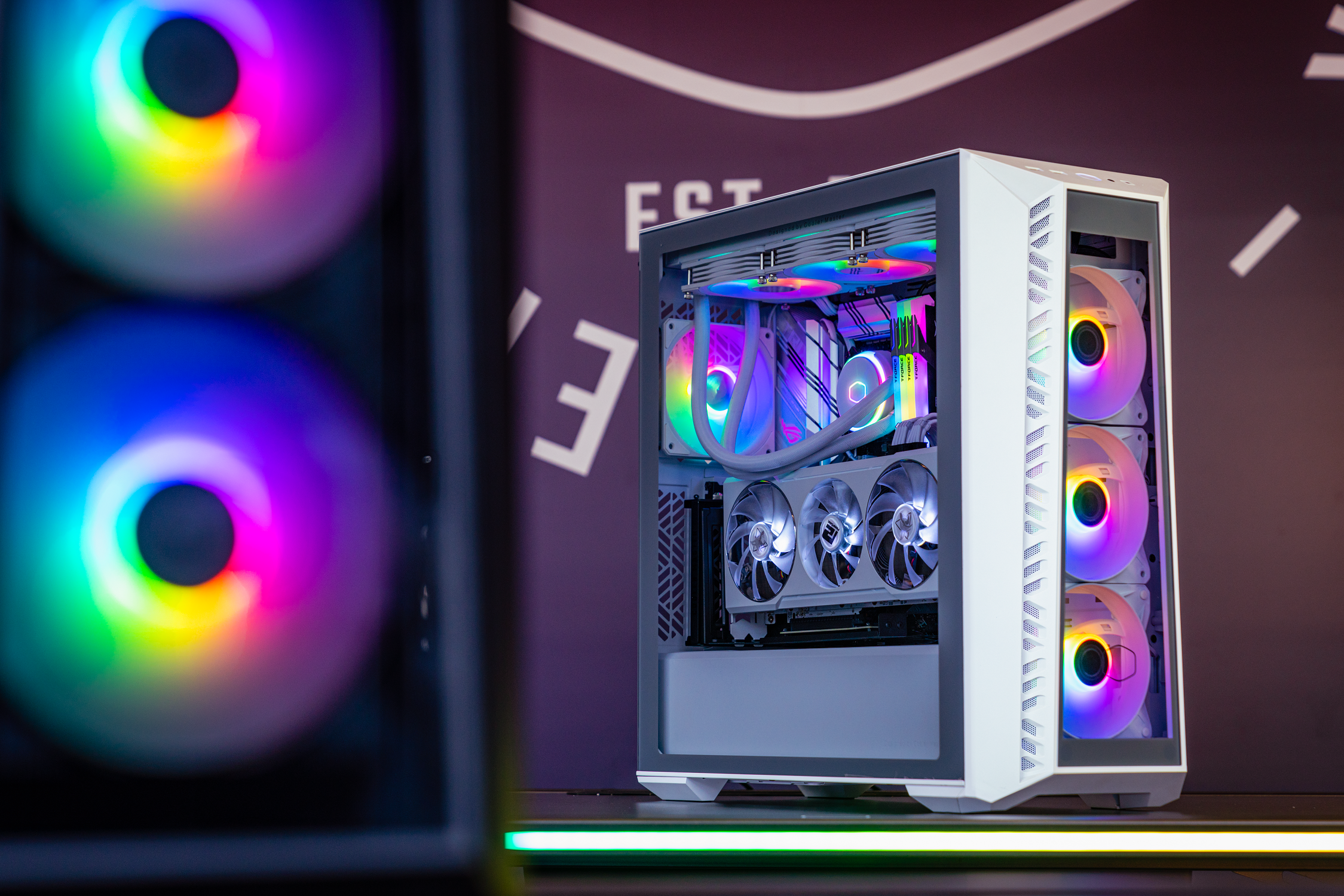 PC para juegos con ventiladores iluminados por RGB. El PC es blanco. Fondo borroso.
