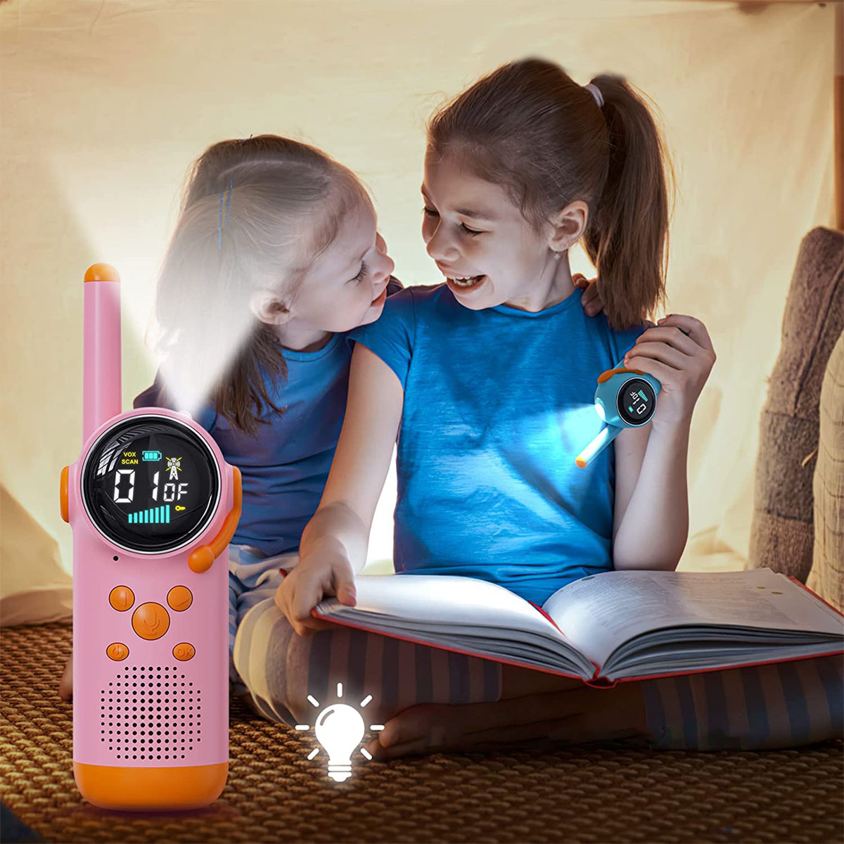 Zwei junge Mädchen mit Walkie-Talkies in einem Zelt. Eines ist beleuchtet.