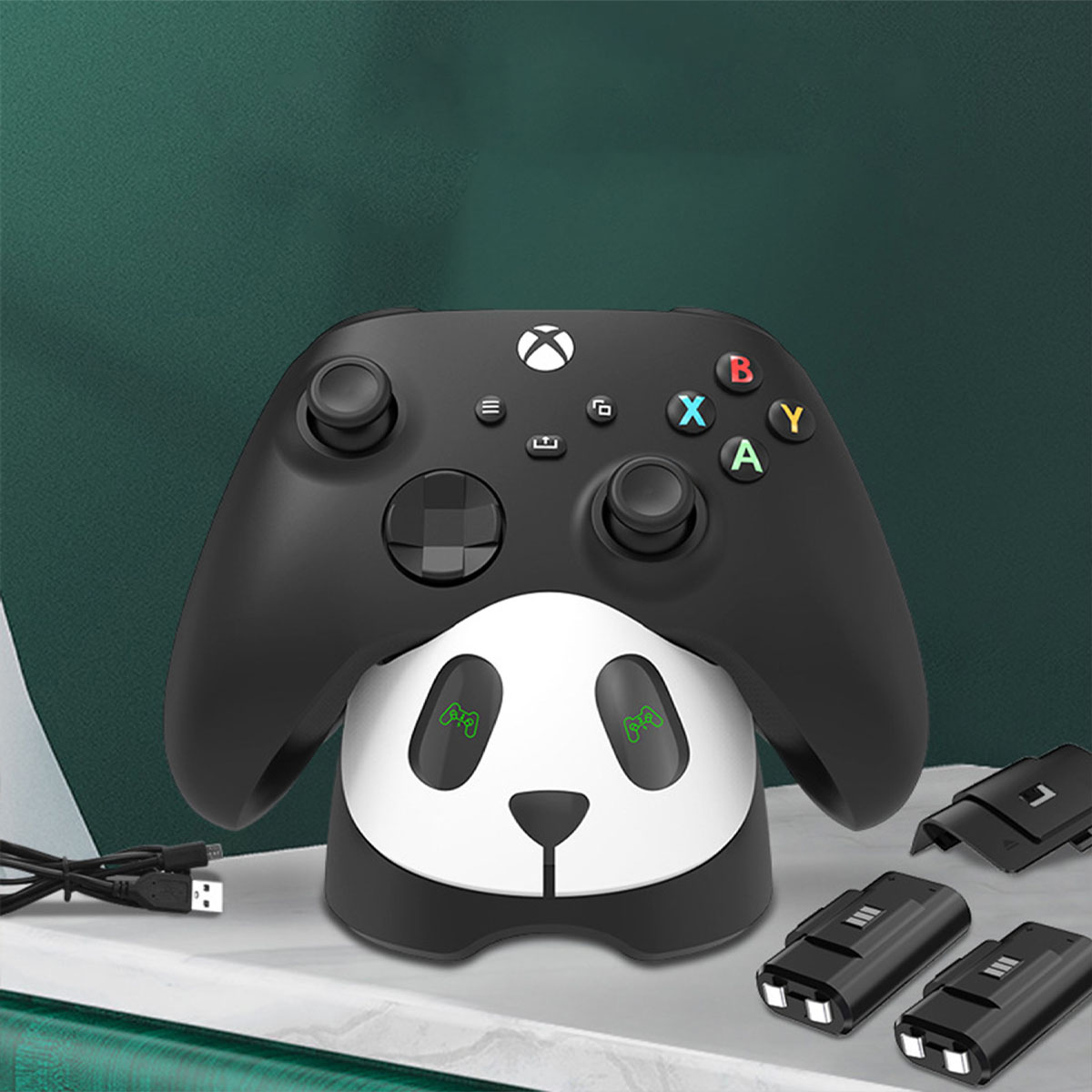 Schwarzer Xbox-Controller auf Panda-Ladestation. Schwarzes Kabel, zwei Ladeanschlüsse, grüner Hintergrund.