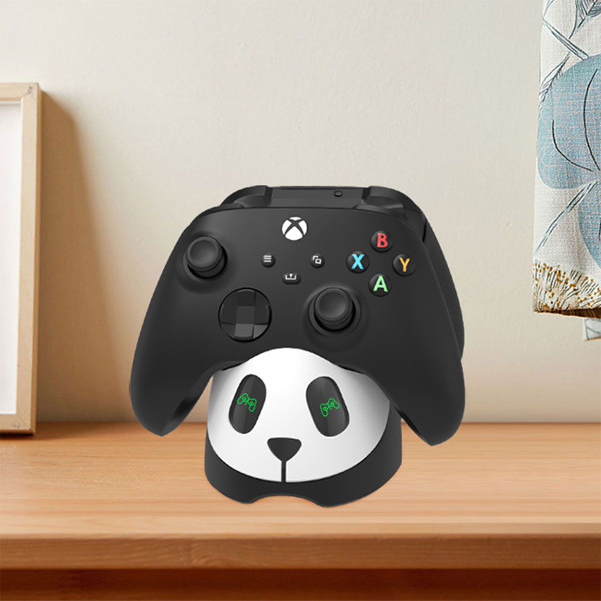 Schwarzer Xbox-Controller auf einem Panda-förmigen Ständer. Die Szene ist drinnen.