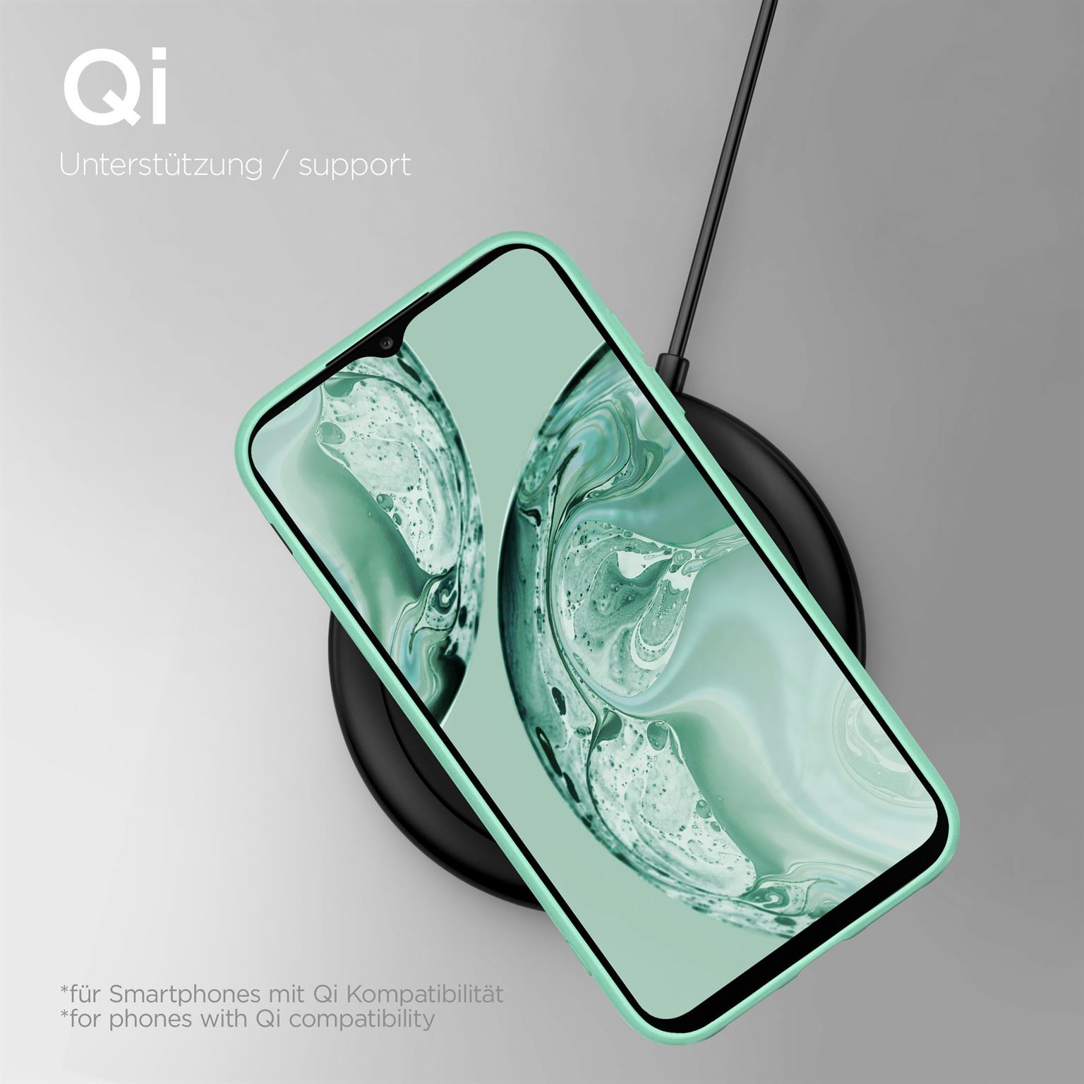 Ein Telefon in einer grünen Hülle liegt auf einem schwarzen kabellosen Ladegerät. Der Hintergrund ist grau.