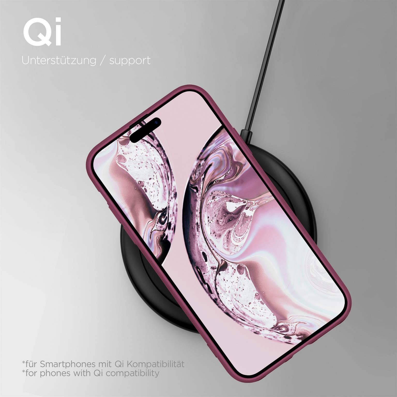 Telefon in einer weinroten Hülle auf einem schwarzen kabellosen Ladegerät. Hülle auf grauem Untergrund.