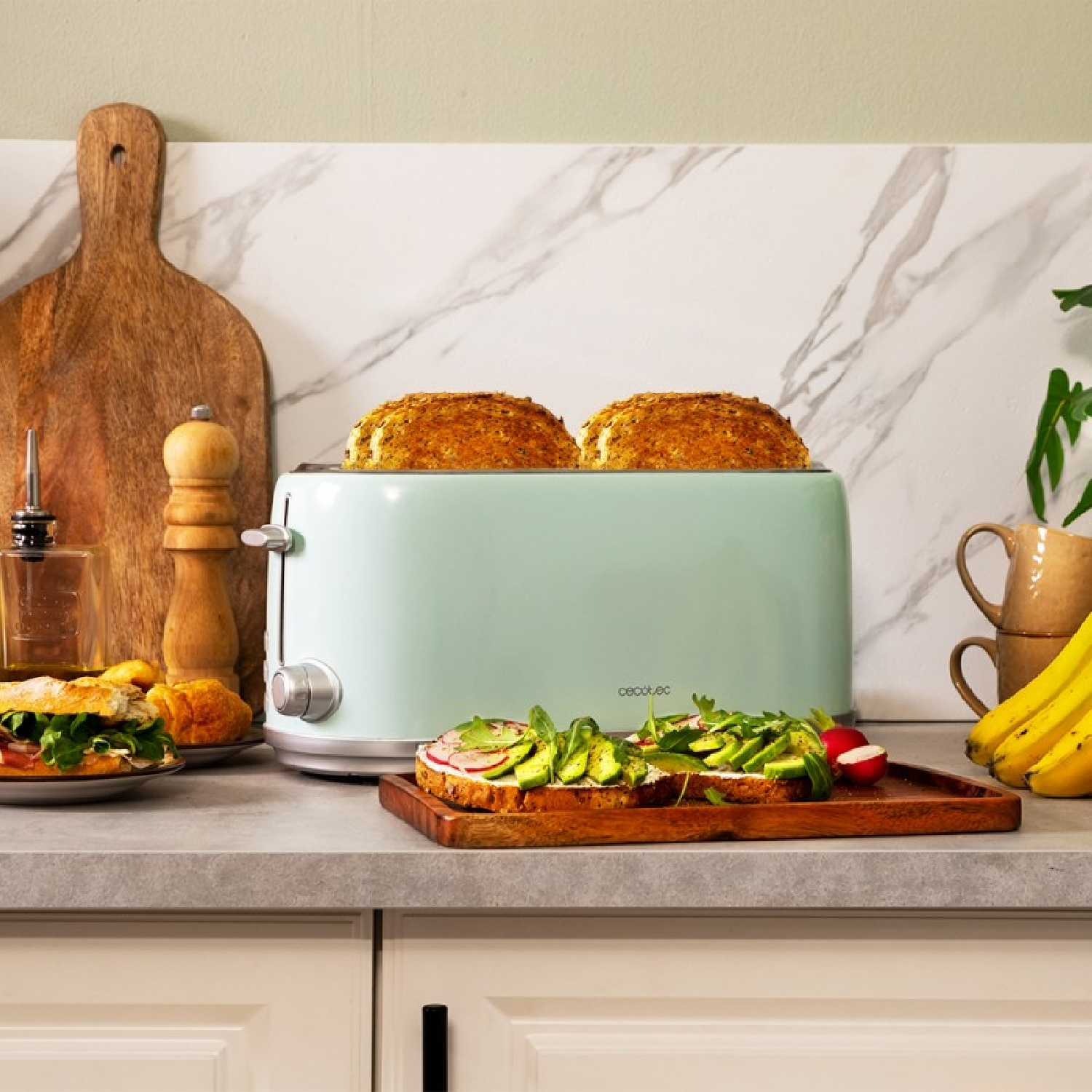 Ein grüner Toaster auf einer Theke toastet Brot. Ein Sandwich und Bananen sind in der Nähe.