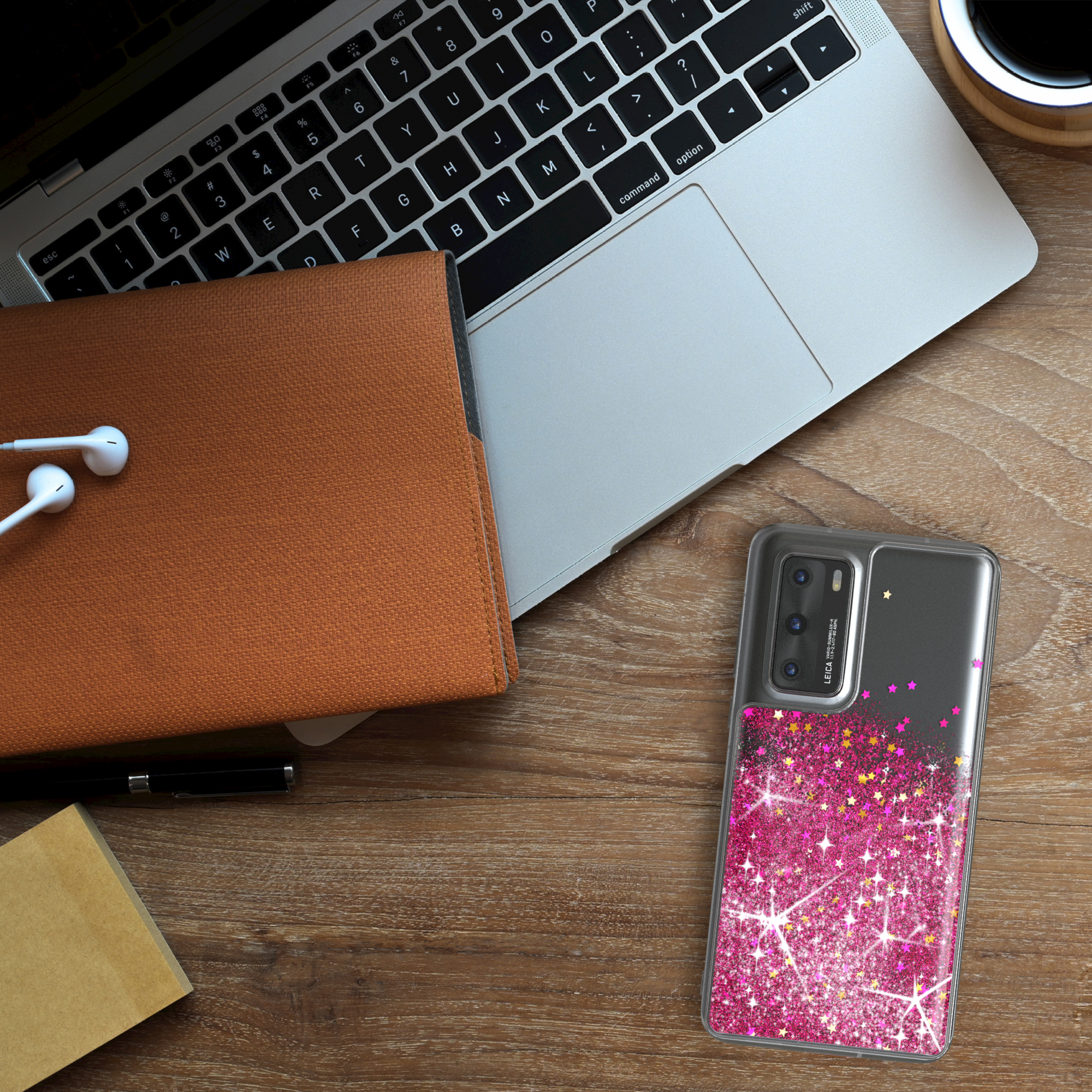 Telefon mit transparenter Hülle auf einem Schreibtisch mit Laptop und Kopfhörern.