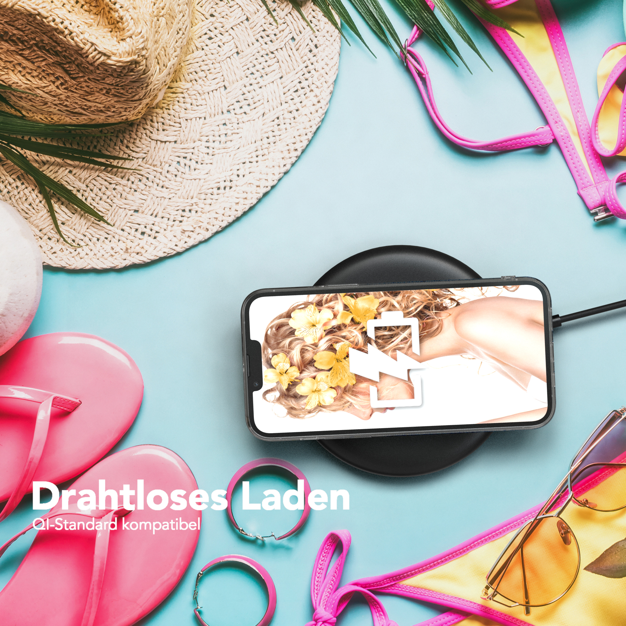 Telefon drahtlos geladen mit Frauenbild auf dem Bildschirm, umgeben von Sommerartikeln.
