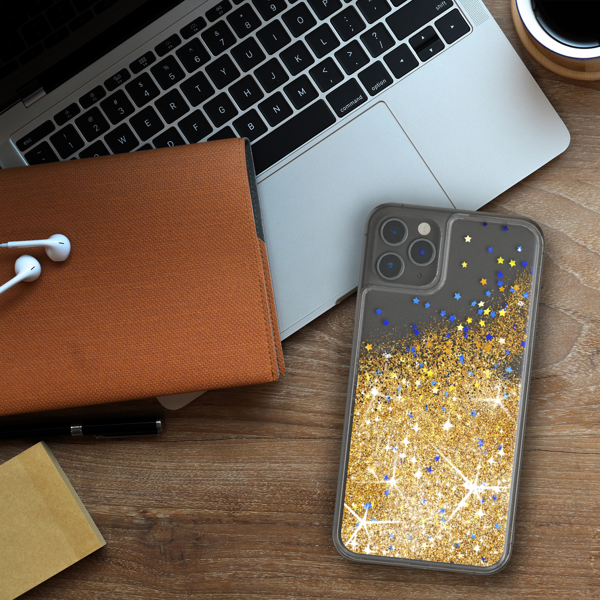 Telefon in Hülle mit Sternen auf einem Holzschreibtisch mit Zubehör.