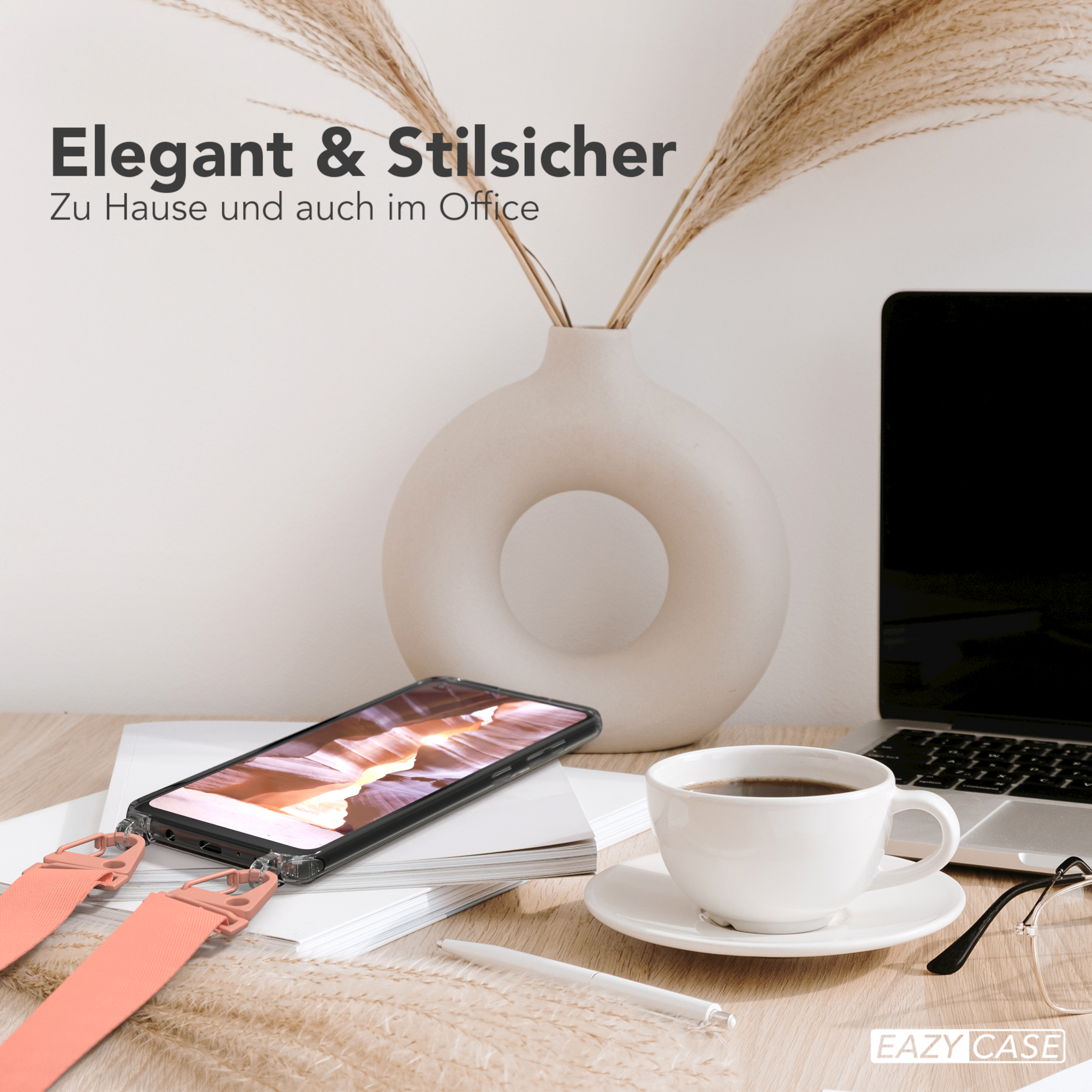 Telefon mit Gurt, Kaffee, Vase und Brille auf einem Schreibtisch. Büro im Hintergrund.