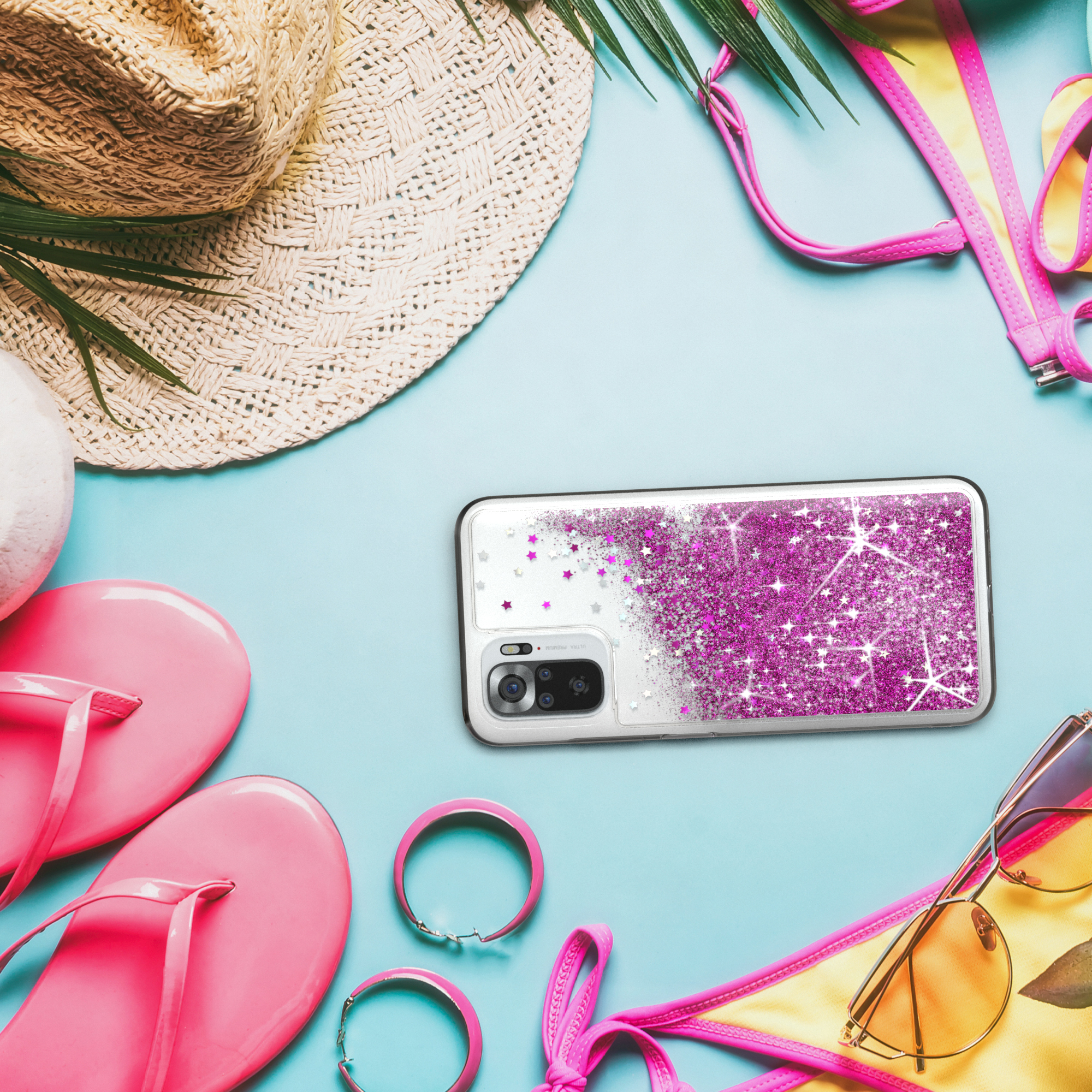 Eine Handyhülle mit rosa Glitzer, umgeben von Sommerartikeln wie Hut, Sonnenbrille und Flip-Flops.