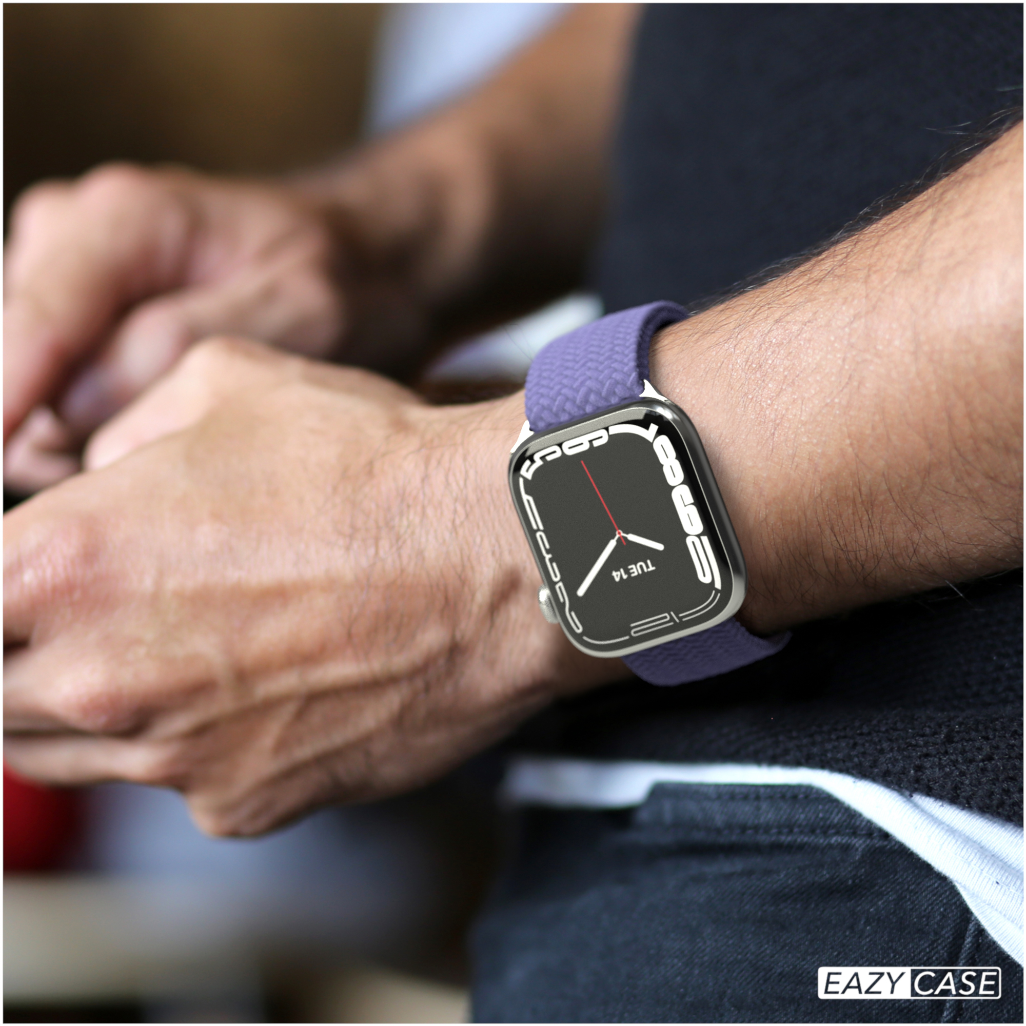 Eine Person trägt ein lilafarbenes Armband mit einer silbernen Uhr.