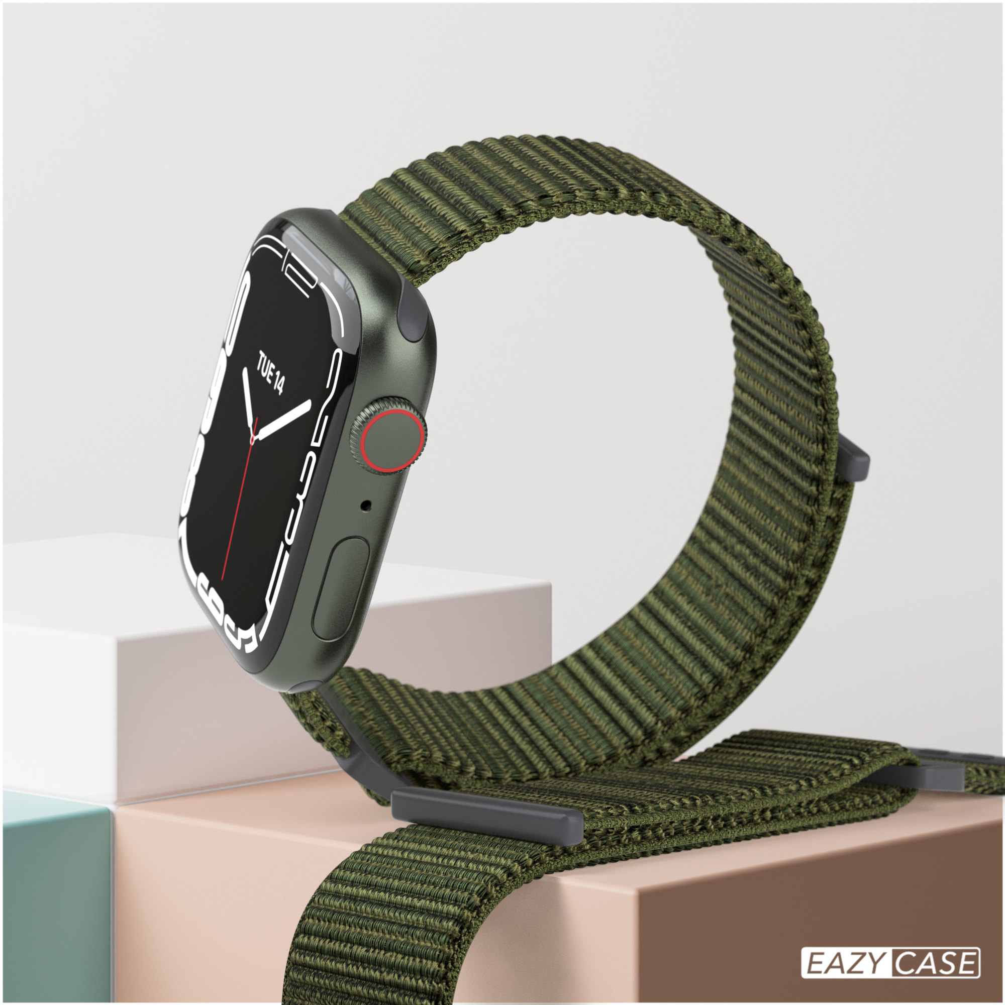 Eine olivgrüne Apple Watch mit einem grünen Stoffband, auf einer weißen und beigen Oberfläche.
