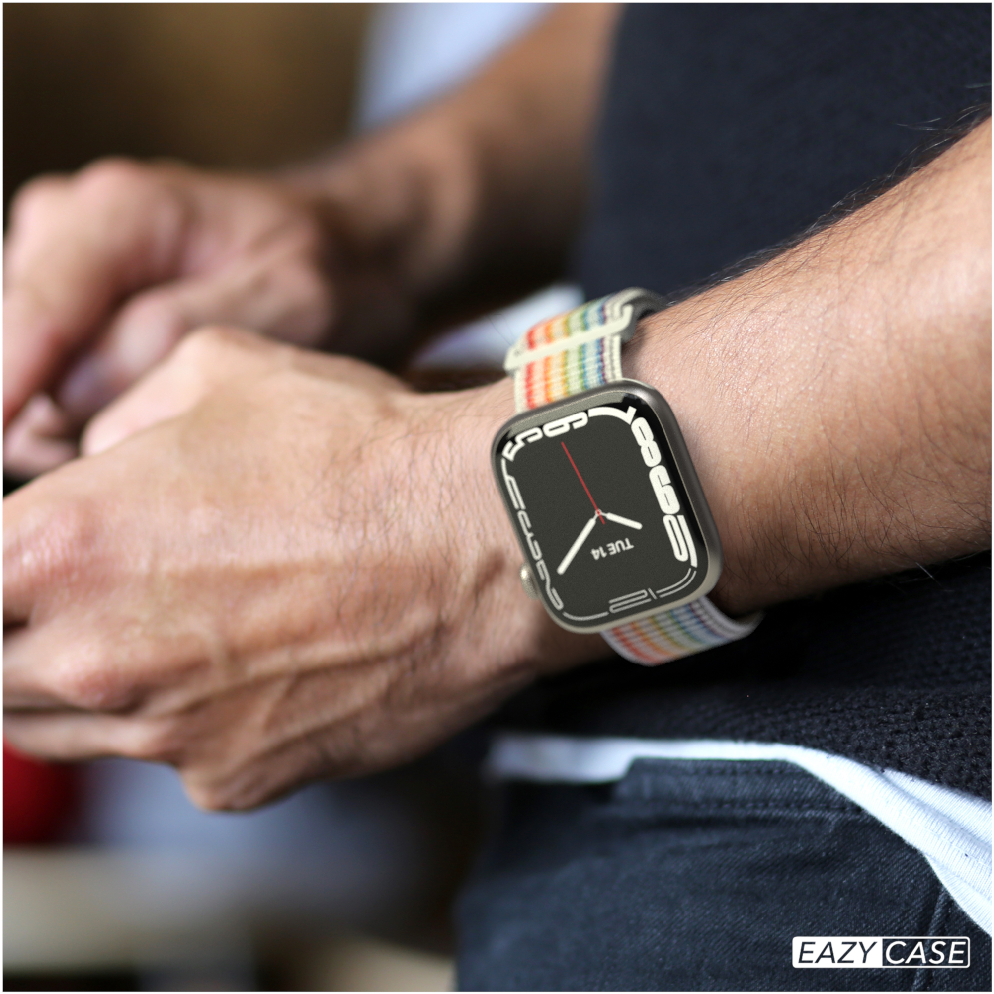 Handgelenk mit Smartwatch und Regenbogenarmband. Schwarzes Hemd. Eazy Case Logo.