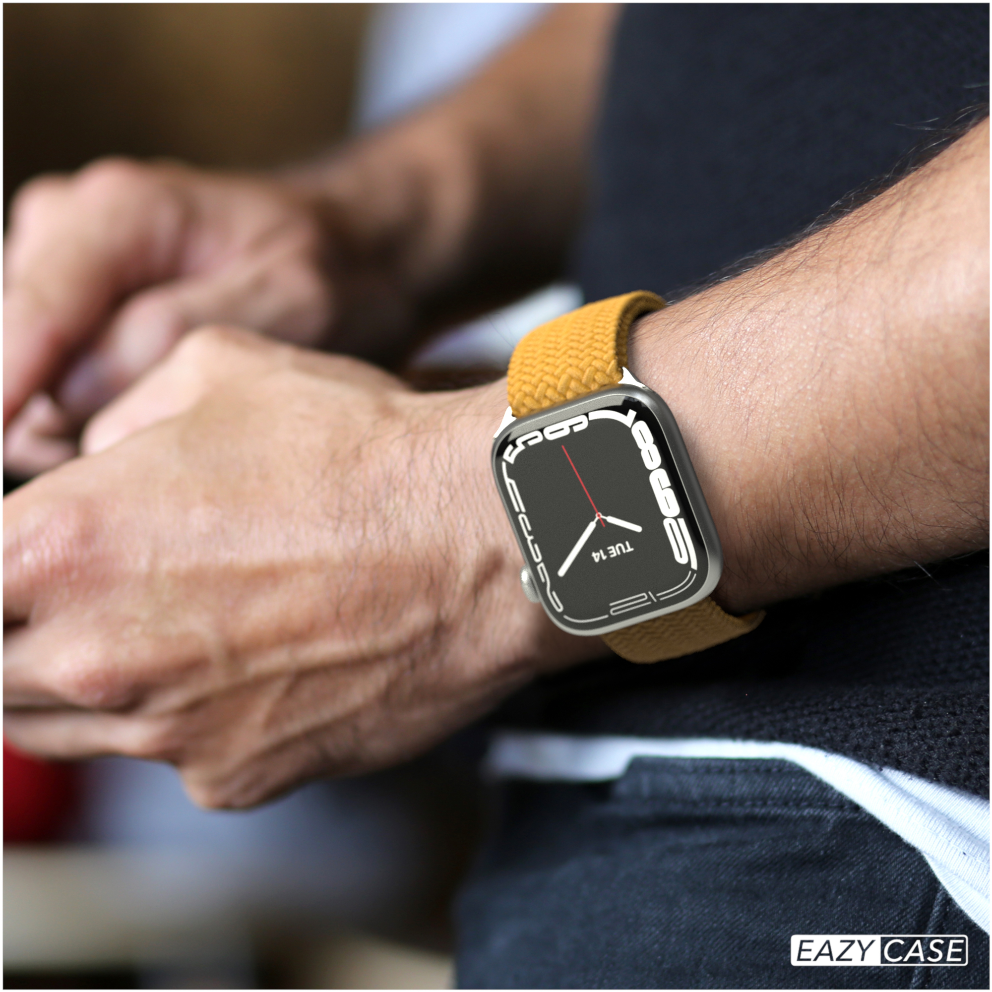 Das Handgelenk einer Person mit einer goldenen Apple Watch und einem gelben Armband.
