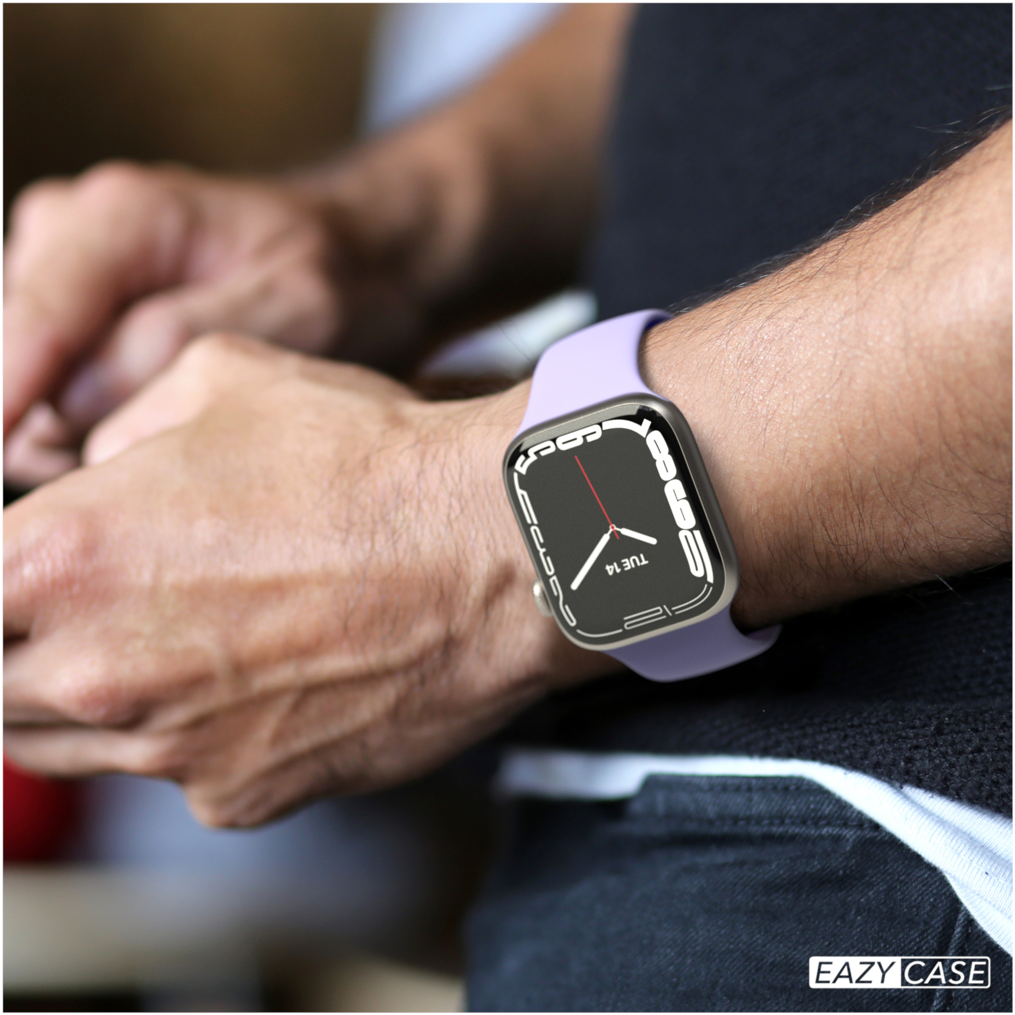 Ein Handgelenk mit einer silbernen Smartwatch mit einem lila Armband ist am Handgelenk einer Person.