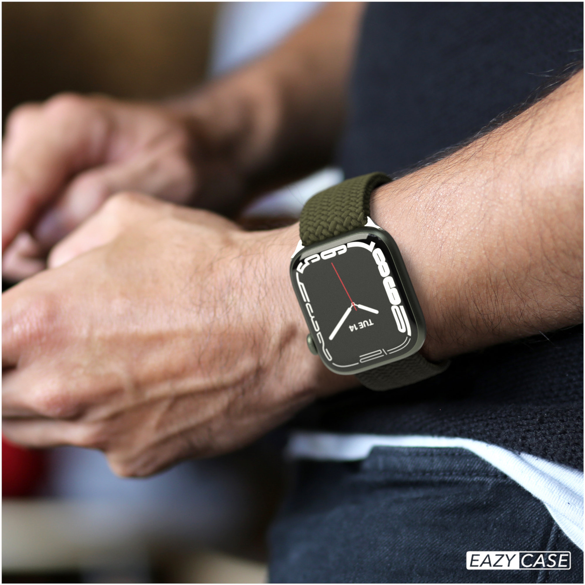 Uhr am Handgelenk. Grünes Uhrenarmband. Hand und schwarzes Hemd sichtbar.