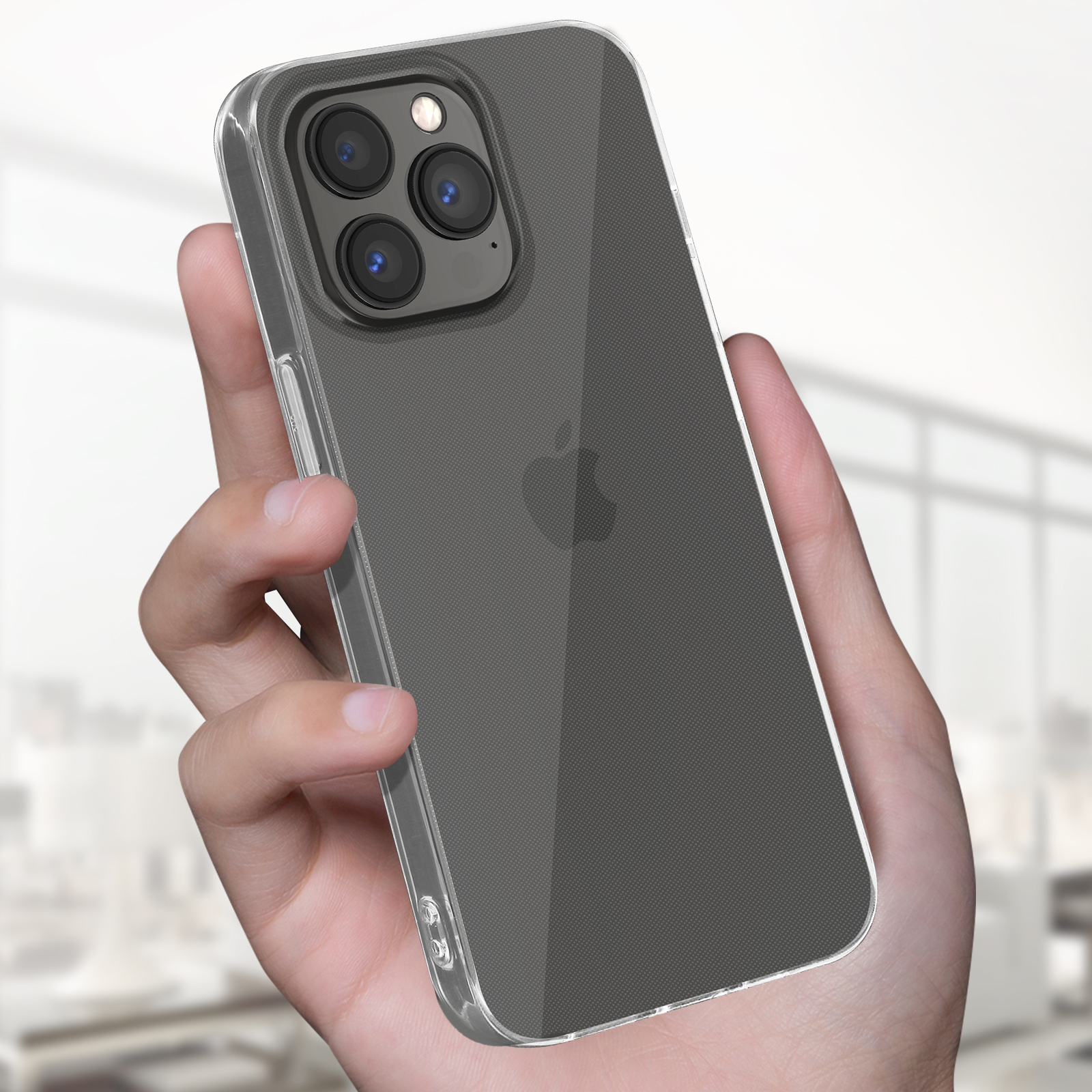 Mano di una persona che tiene un telefono in una custodia trasparente. Il telefono è un iPhone, lo sfondo è sfocato.