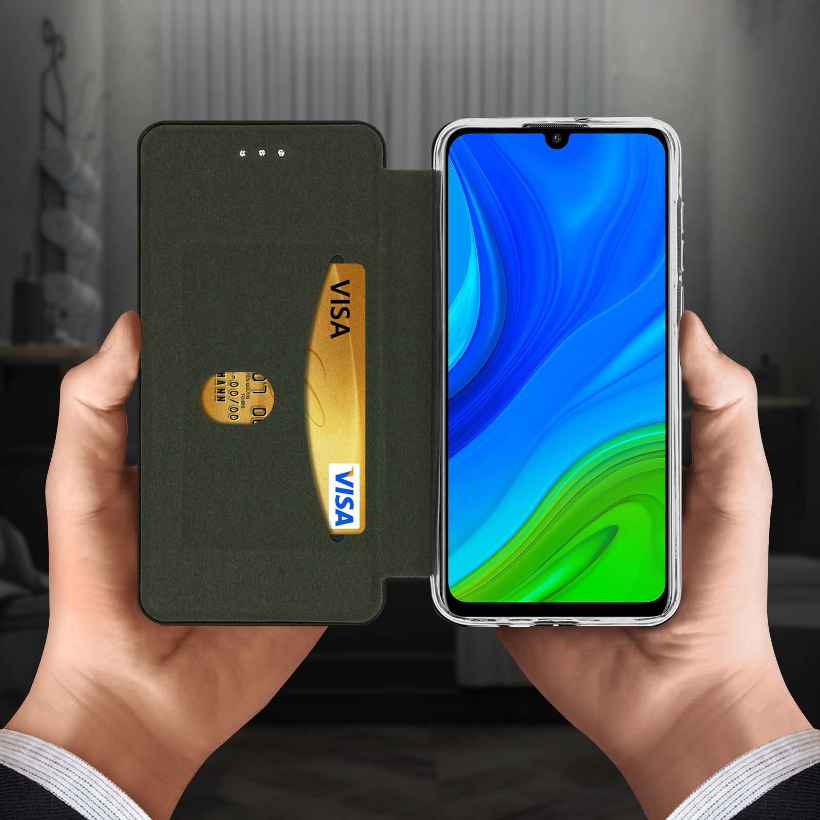 Hände halten ein Telefon mit Kartensteckplatz und Visa-Karte. Grüne und schwarze Hülle. Verschwommener Hintergrund.