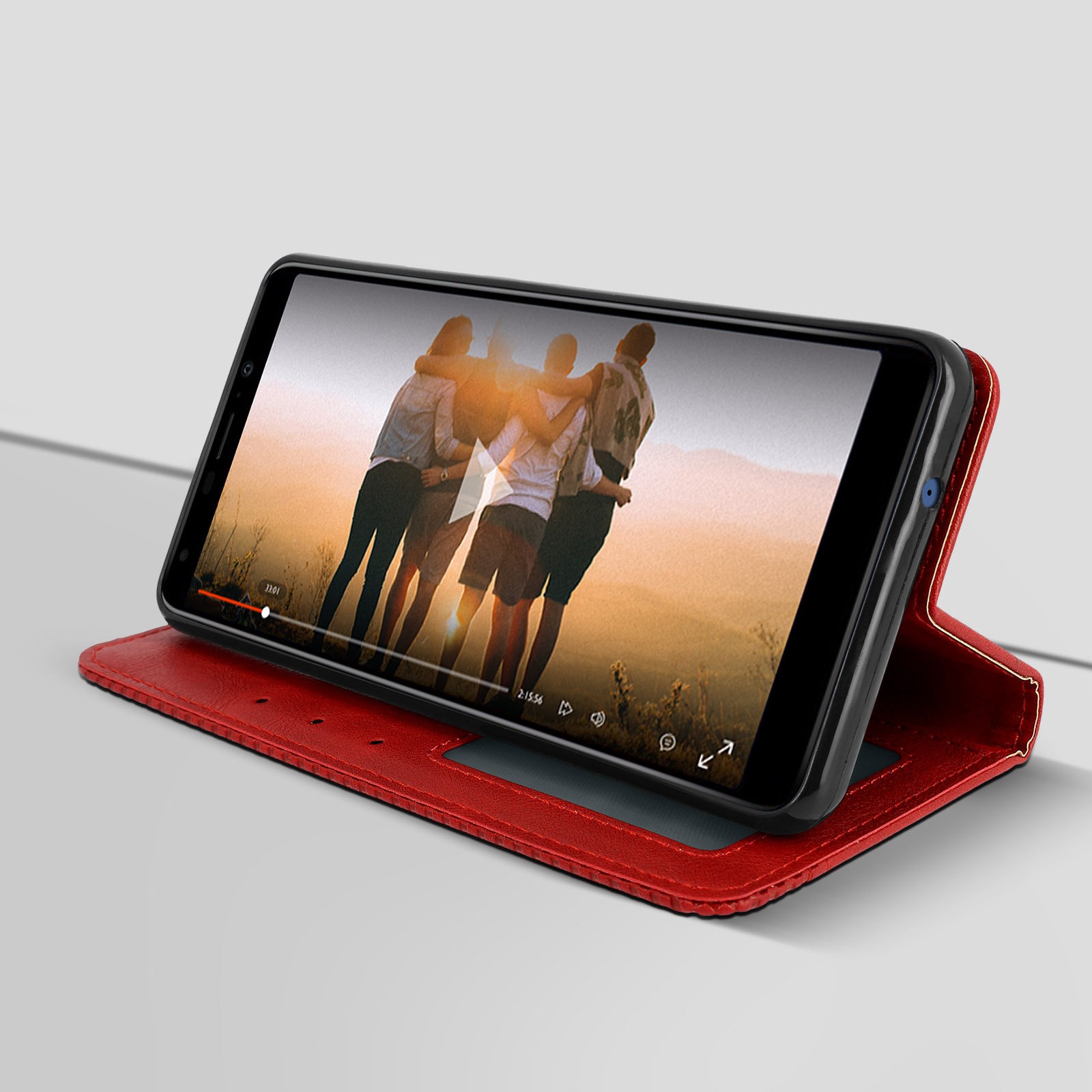 Teléfono en funda roja mostrando un video de tres personas abrazándose.