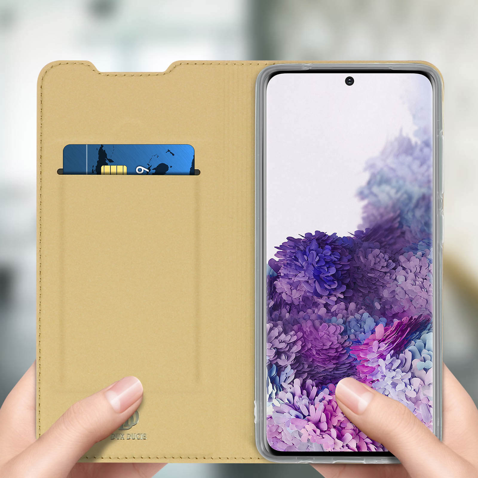 Telefon in geöffneter Brieftasche. Das Etui ist beige, eine Karte in der Tasche. Der Hintergrund ist ein Raum.