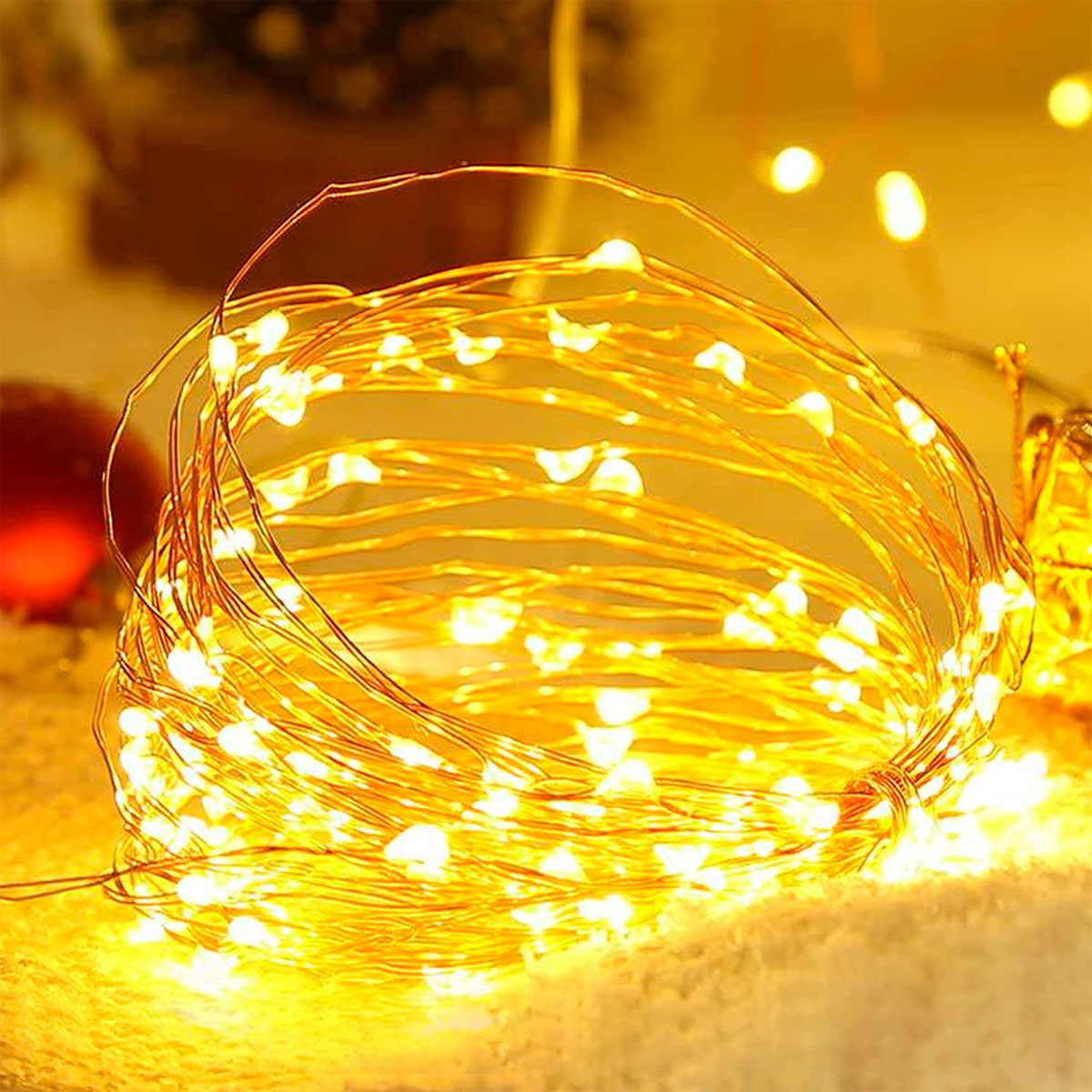 Eine aufgerollte Schnur mit warmen, gelben Lichterketten. Die Lichter sind verheddert.