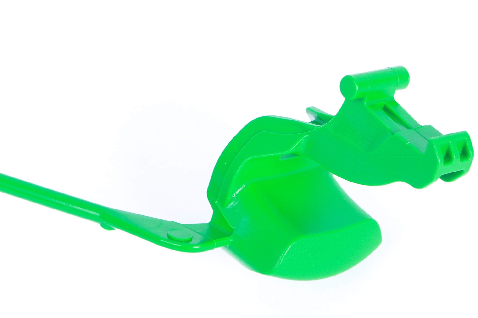 Ein grünes Plastikobjekt mit langem Griff, das einem Drachenkopf ähnelt.