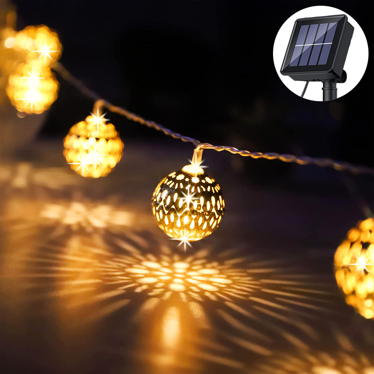 Solarbetriebene Lichterkette. Goldene Kugel-Lichter mit Schatten. Ein kleines Solarpanel ist sichtbar.