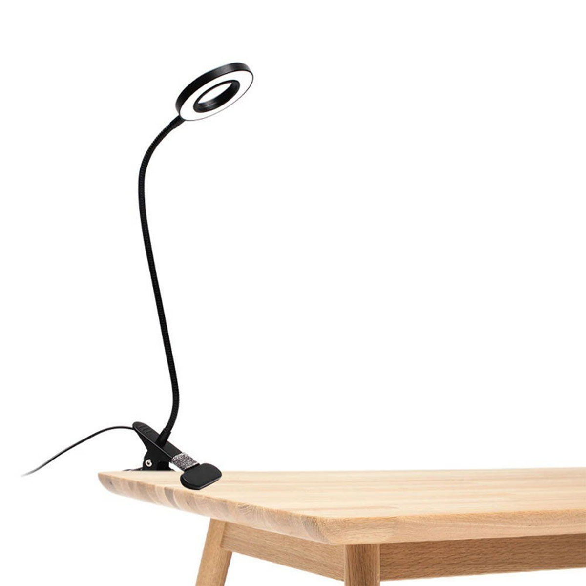 Una lámpara de escritorio negra y flexible con luz de anillo en la parte superior y clip.