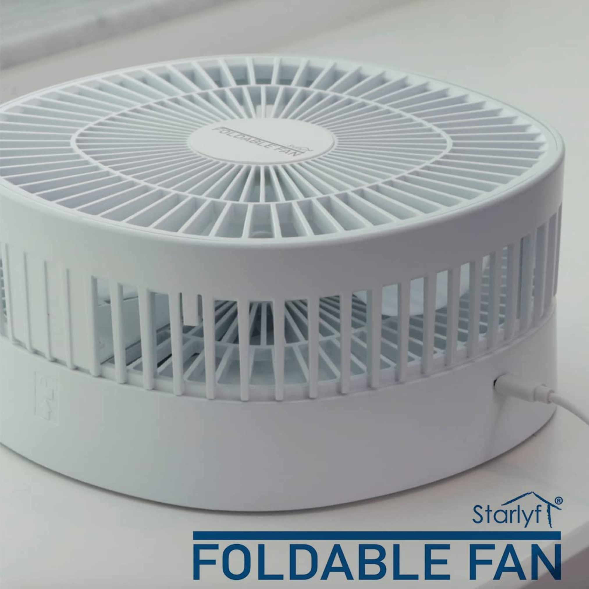 Ein weißer, zusammenklappbarer Ventilator auf einer weißen Oberfläche, mit dem Markennamen 'Starlyf'.