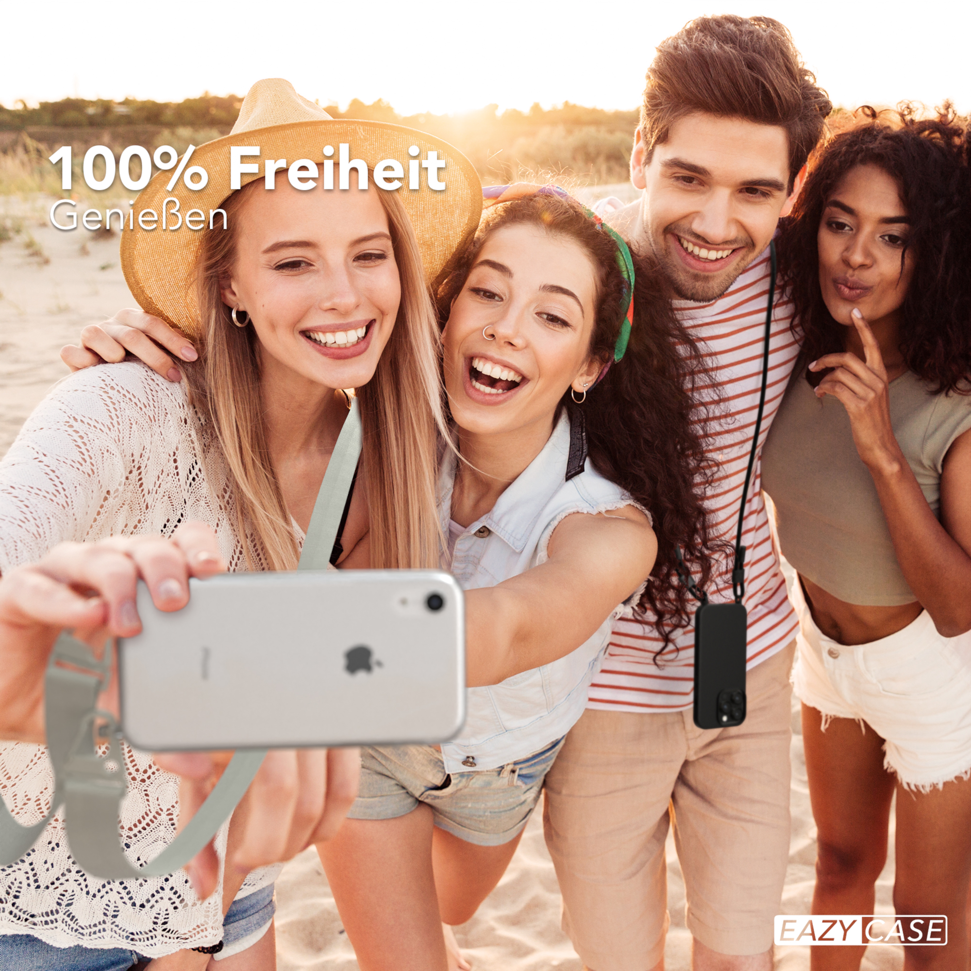 Vier Personen machen ein Selfie am Strand. Sie lächeln und halten ein Telefon.