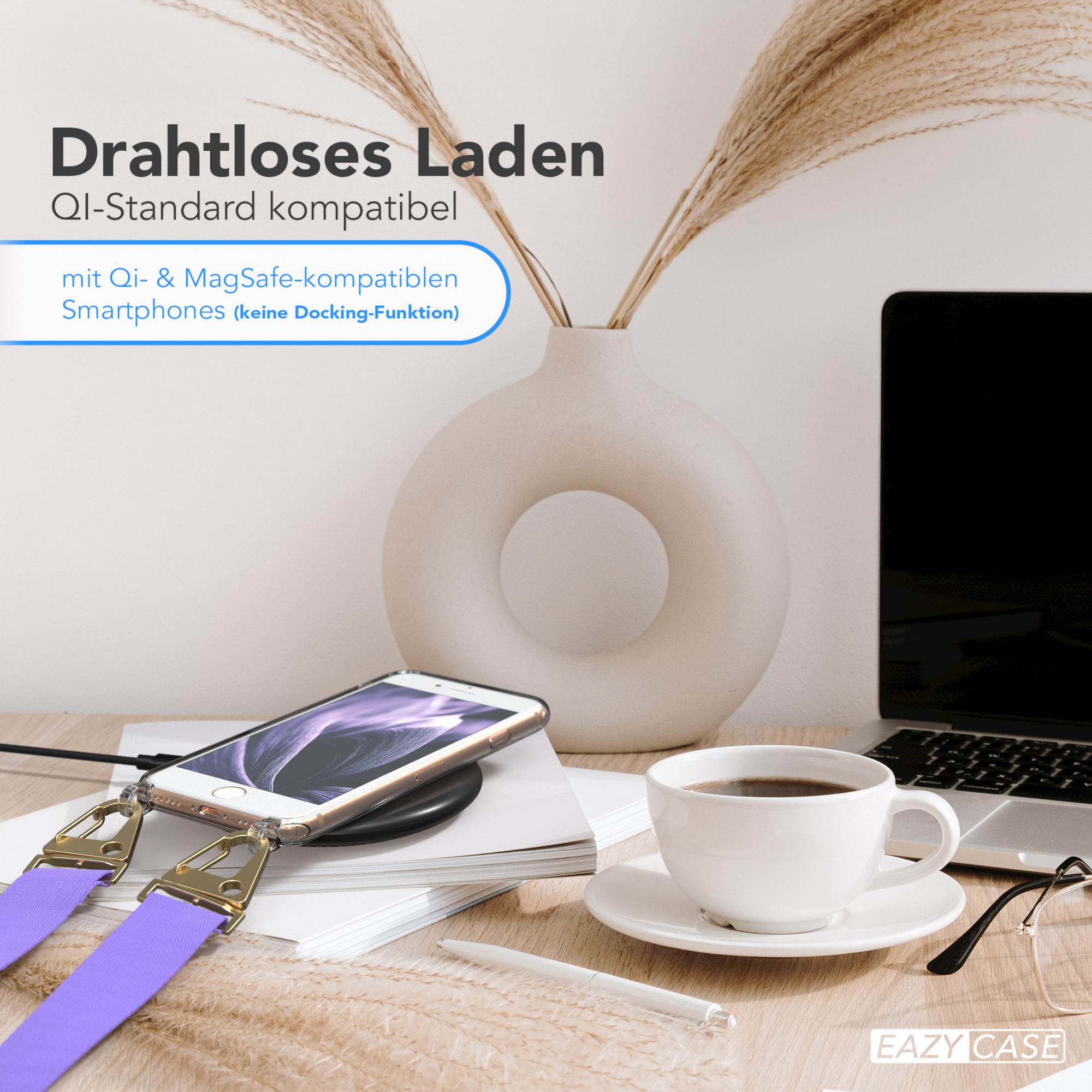 Telefon, der drahtlos auf einem Schreibtisch geladen wird. Eine Tasse Kaffee, ein Laptop und eine Vase mit Blumen.