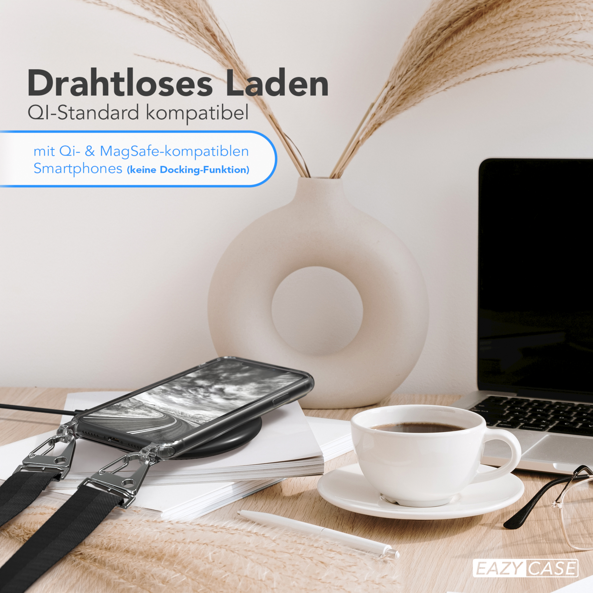 Ein Telefon liegt auf einem kabellosen Ladegerät. Eine Kaffeetasse und eine Brille stehen auf dem Tisch.