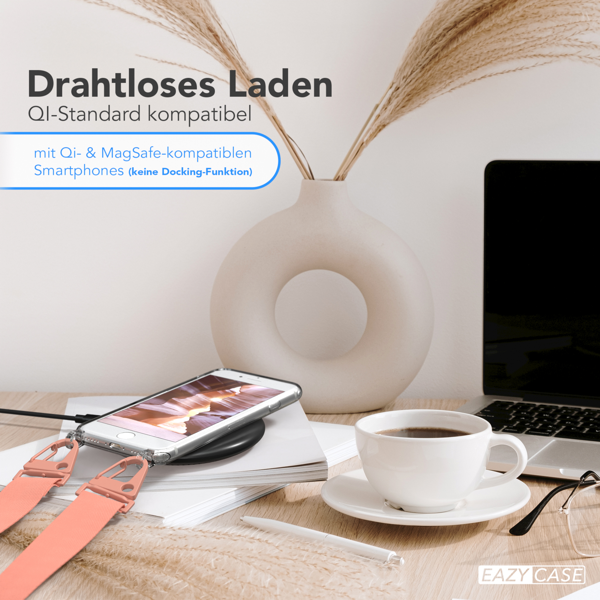Ein Telefon auf einem kabellosen Ladegerät, mit einer Kaffeetasse und einem Laptop.