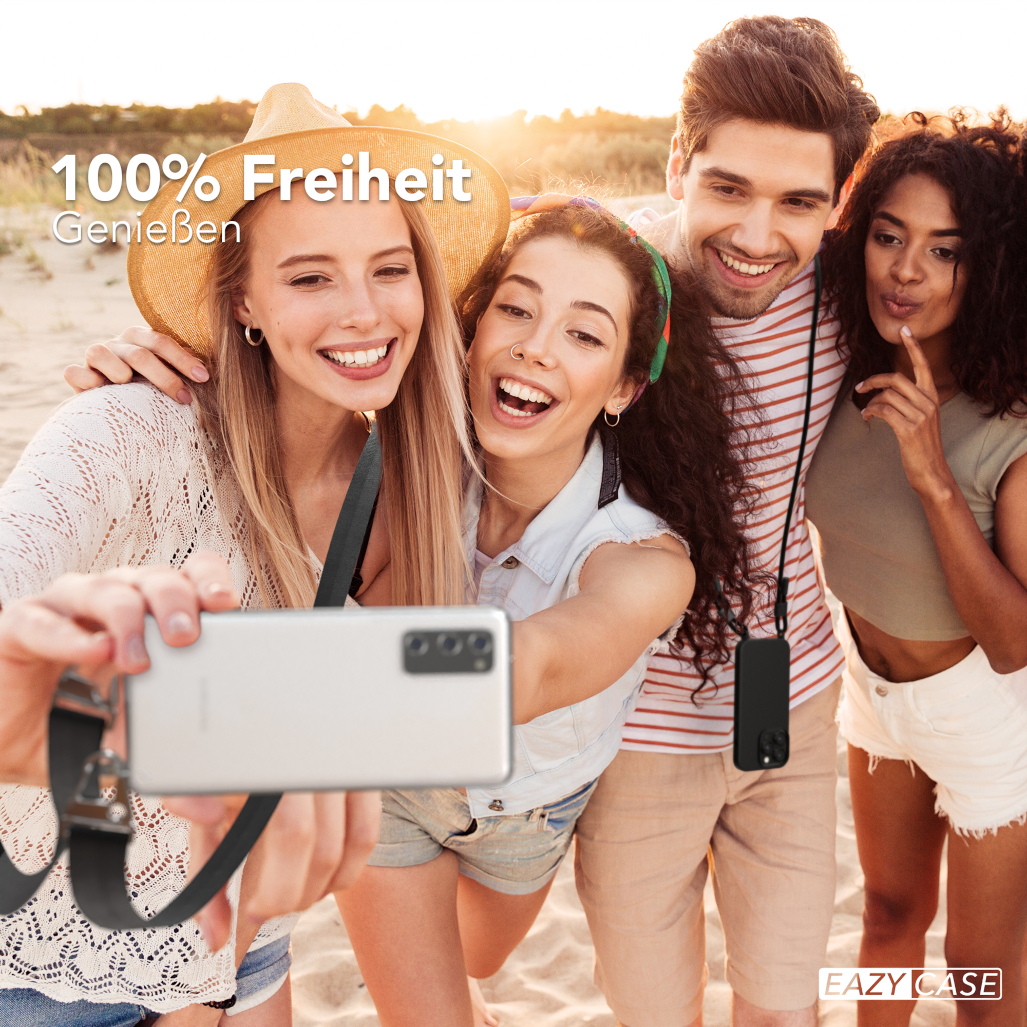 Vier Freunde am Strand machen ein Selfie. Einer hält das Telefon mit einem Schlüsselband.