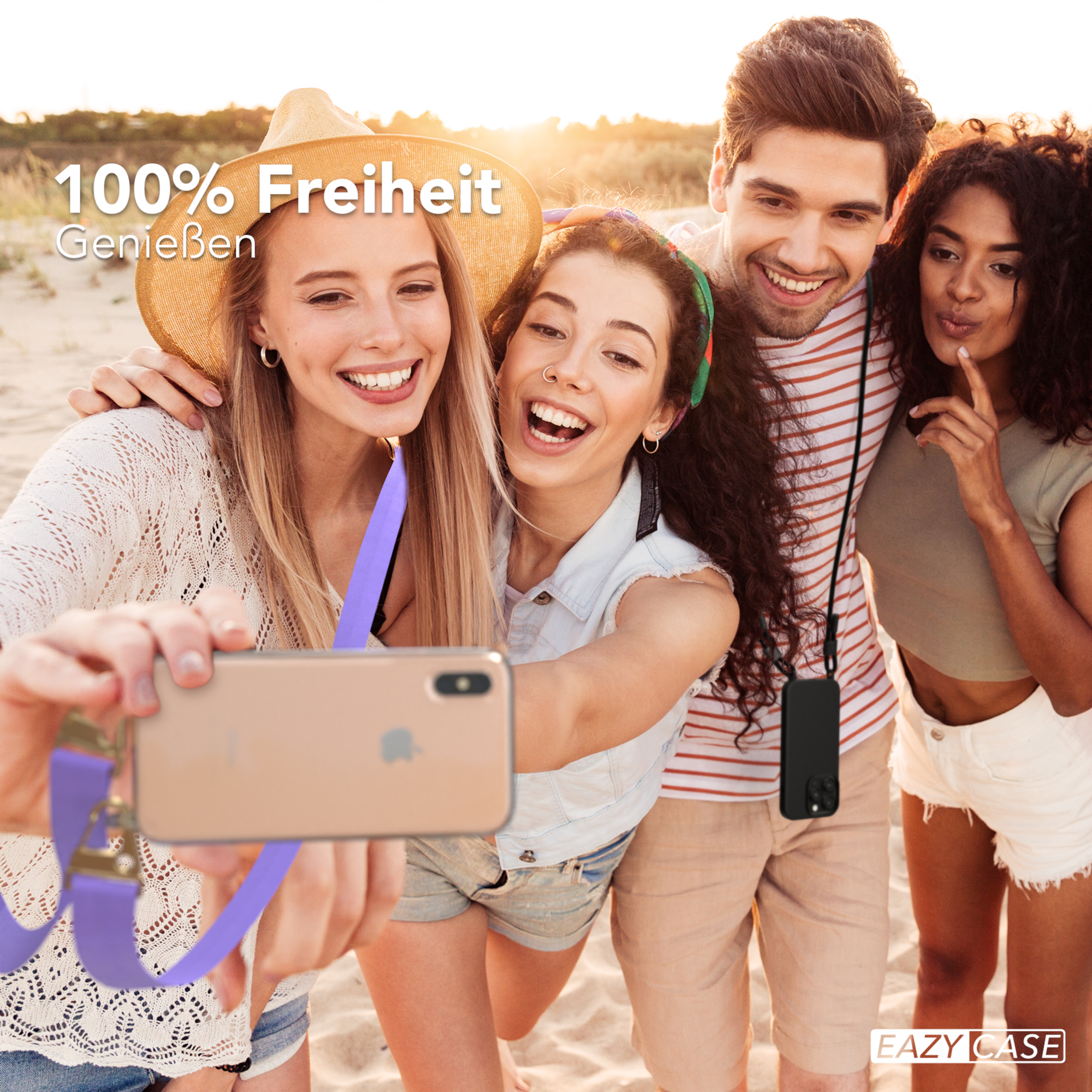 Vier junge Leute machen ein Selfie am Strand. Sie lächeln und halten ein Telefon.