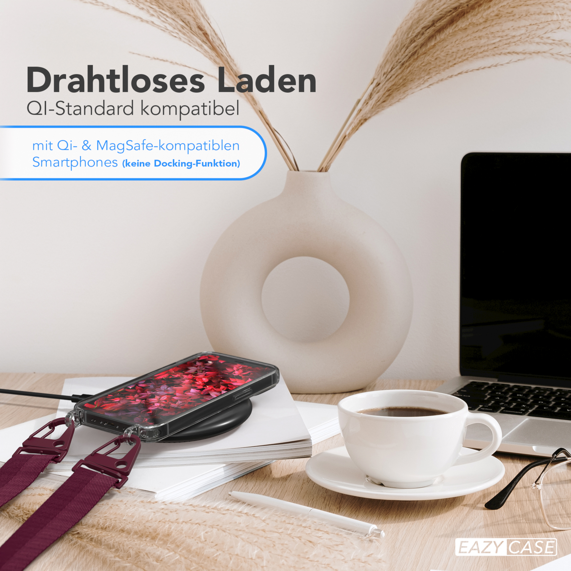 Ein Telefon auf einem kabellosen Ladegerät mit rotem-Blumen-Case. Eine Tasse und Brille auf dem Tisch.