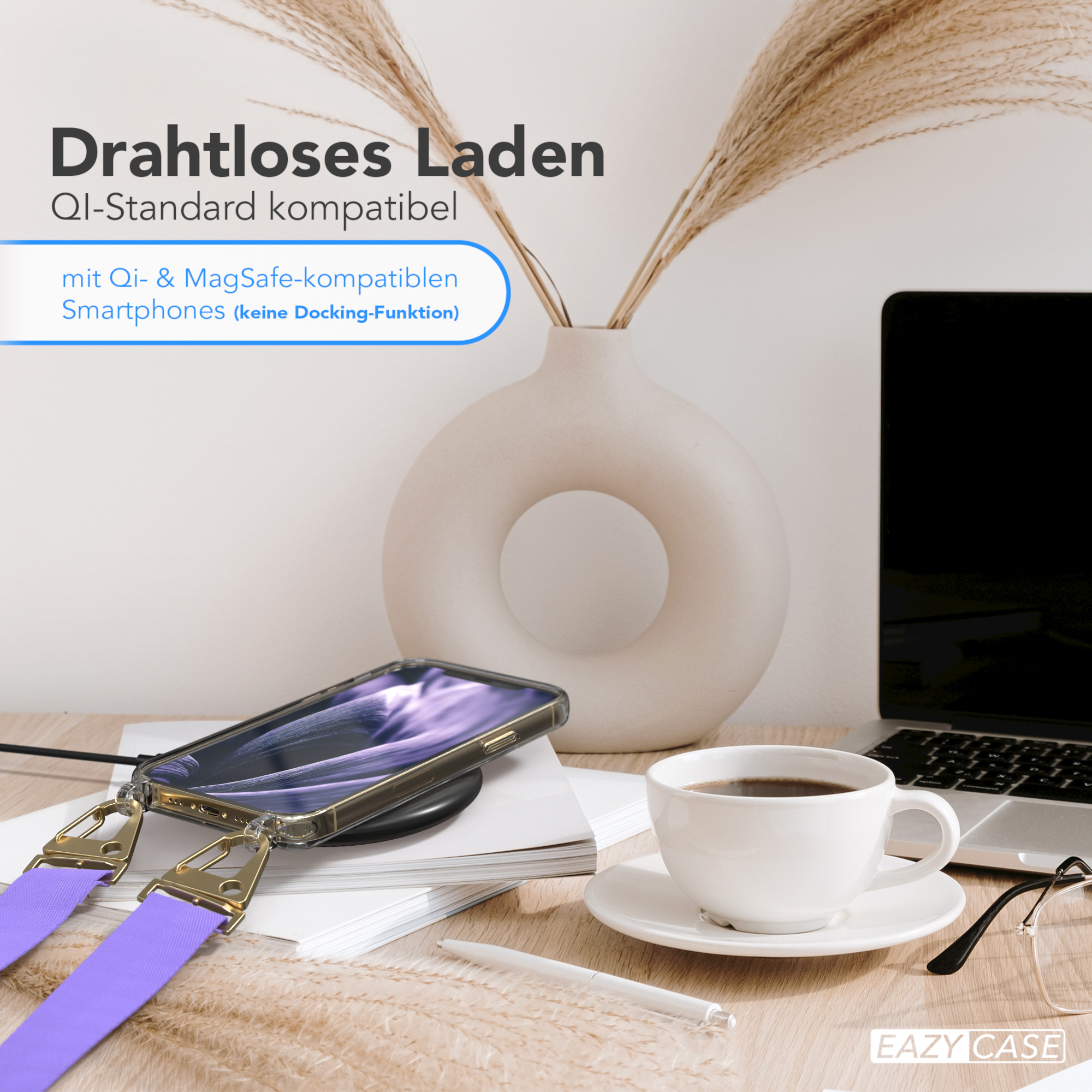 Telefon, der drahtlos auf einem Schreibtisch geladen wird. Eine Tasse Kaffee, ein Laptop und eine Vase mit Blumen.