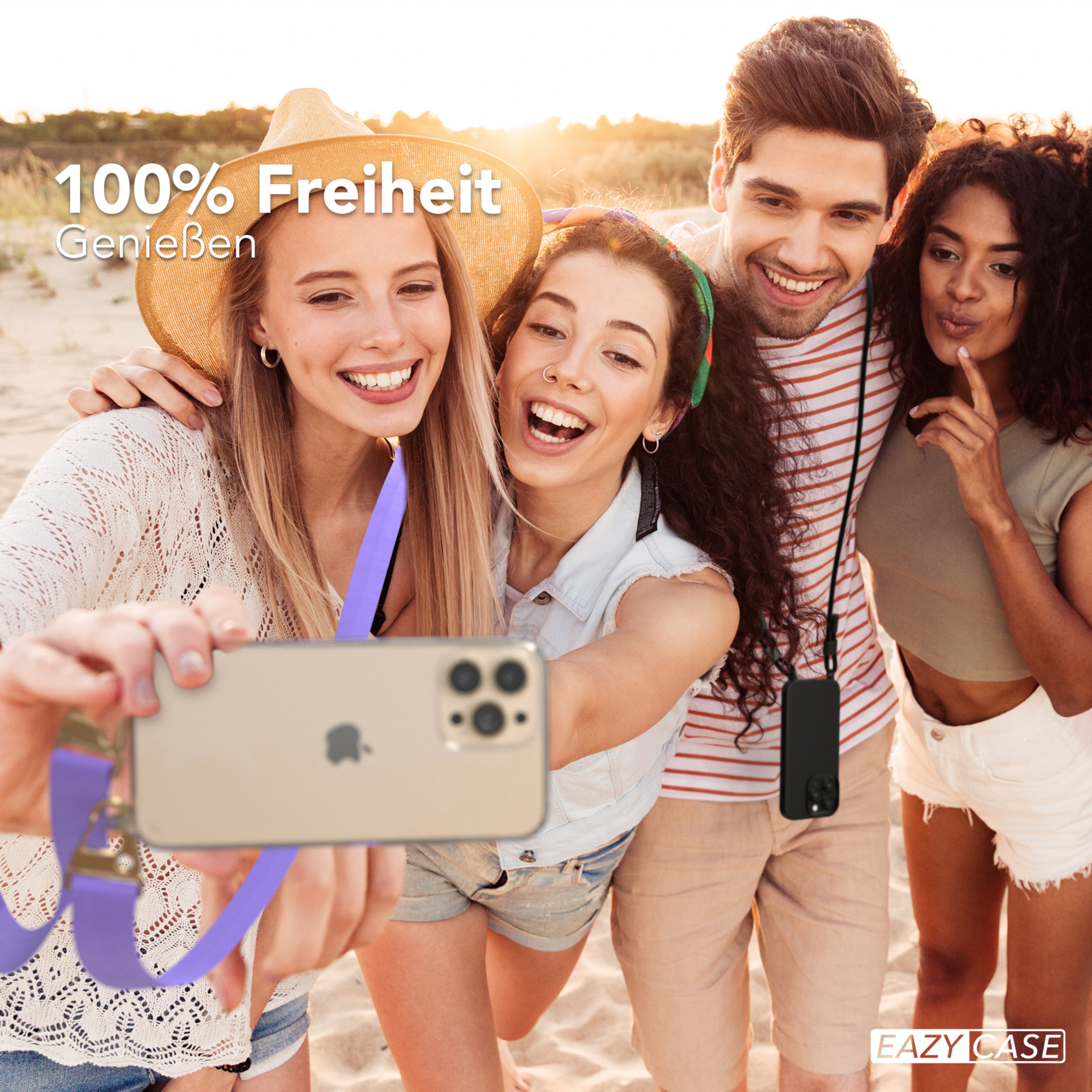 Vier Freunde am Strand machen ein Selfie. Einer hält das Telefon mit einem lila Schlüsselband.