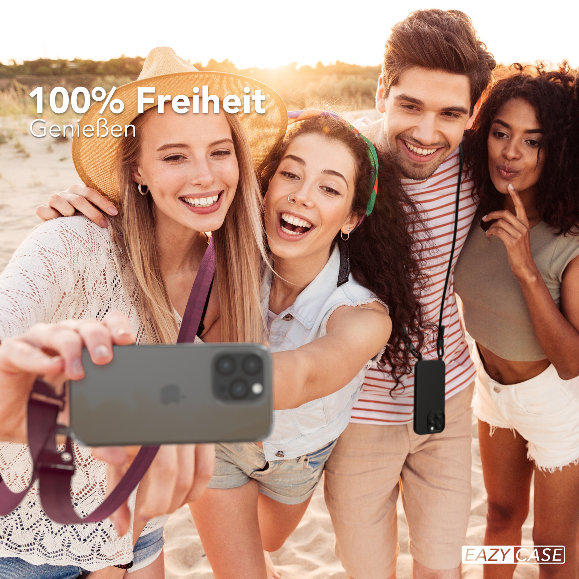 Vier Personen machen ein Selfie mit einem Telefon am Gurt am Strand.