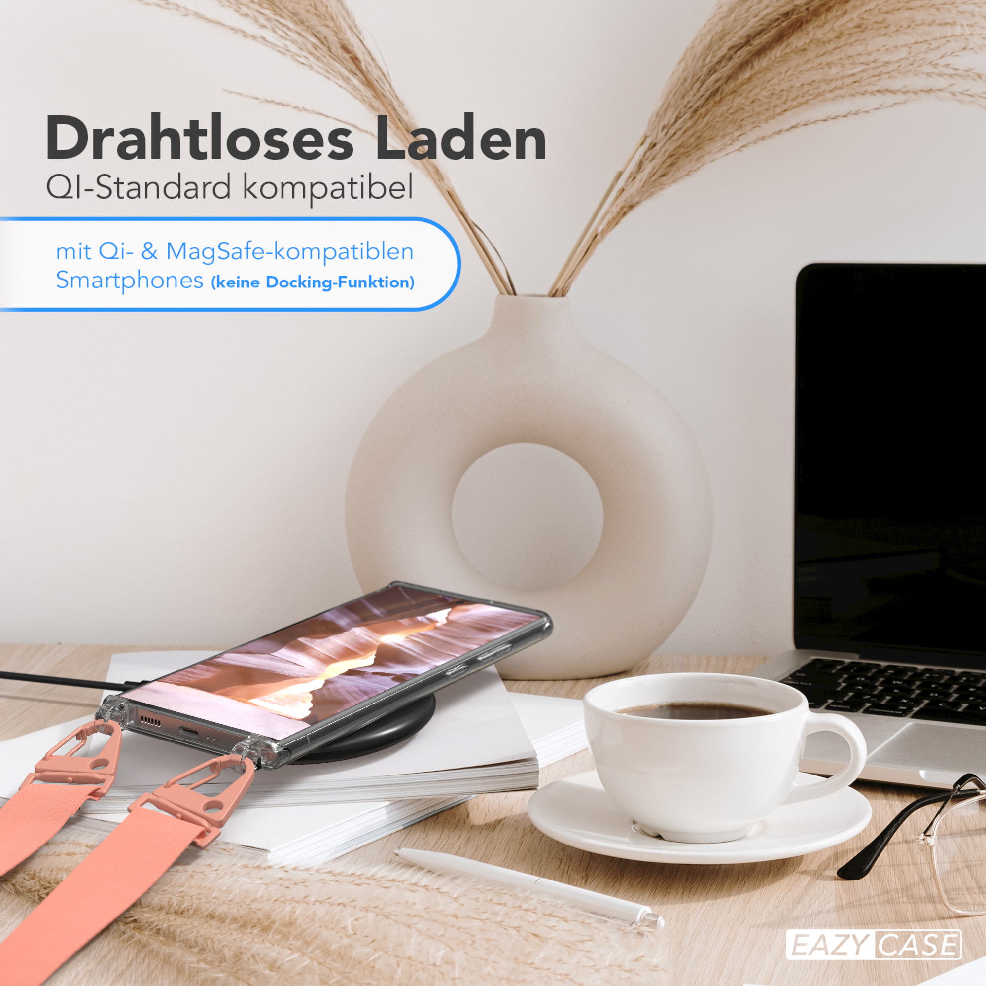 Telefon auf kabellosem Ladegerät, Kaffeetasse, Laptop, Vase mit Pflanze und Stift auf Holzschreibtisch.
