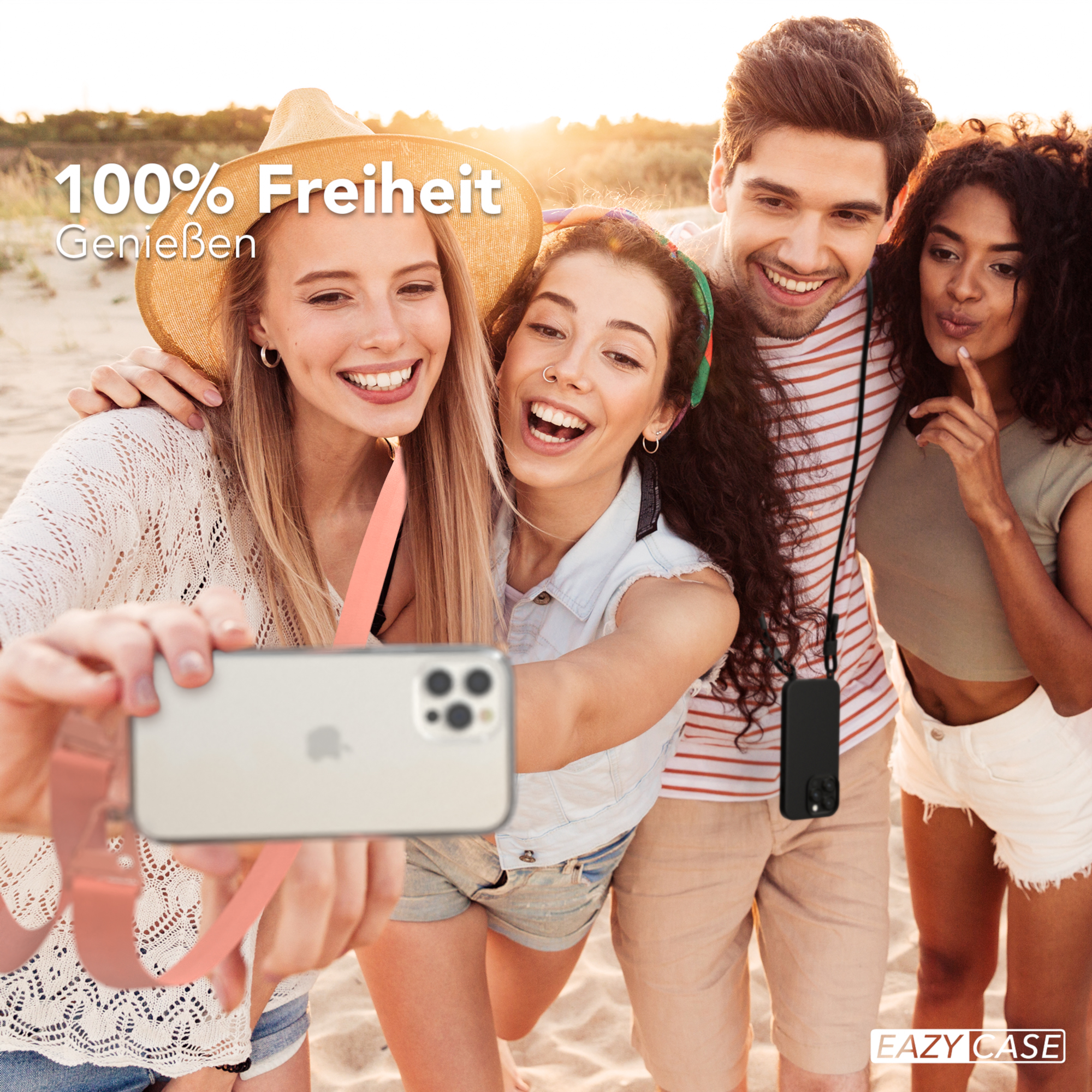 Vier Personen machen ein Selfie mit einem Telefon. Einer trägt einen Strohhut, andere lächeln, am Strand.