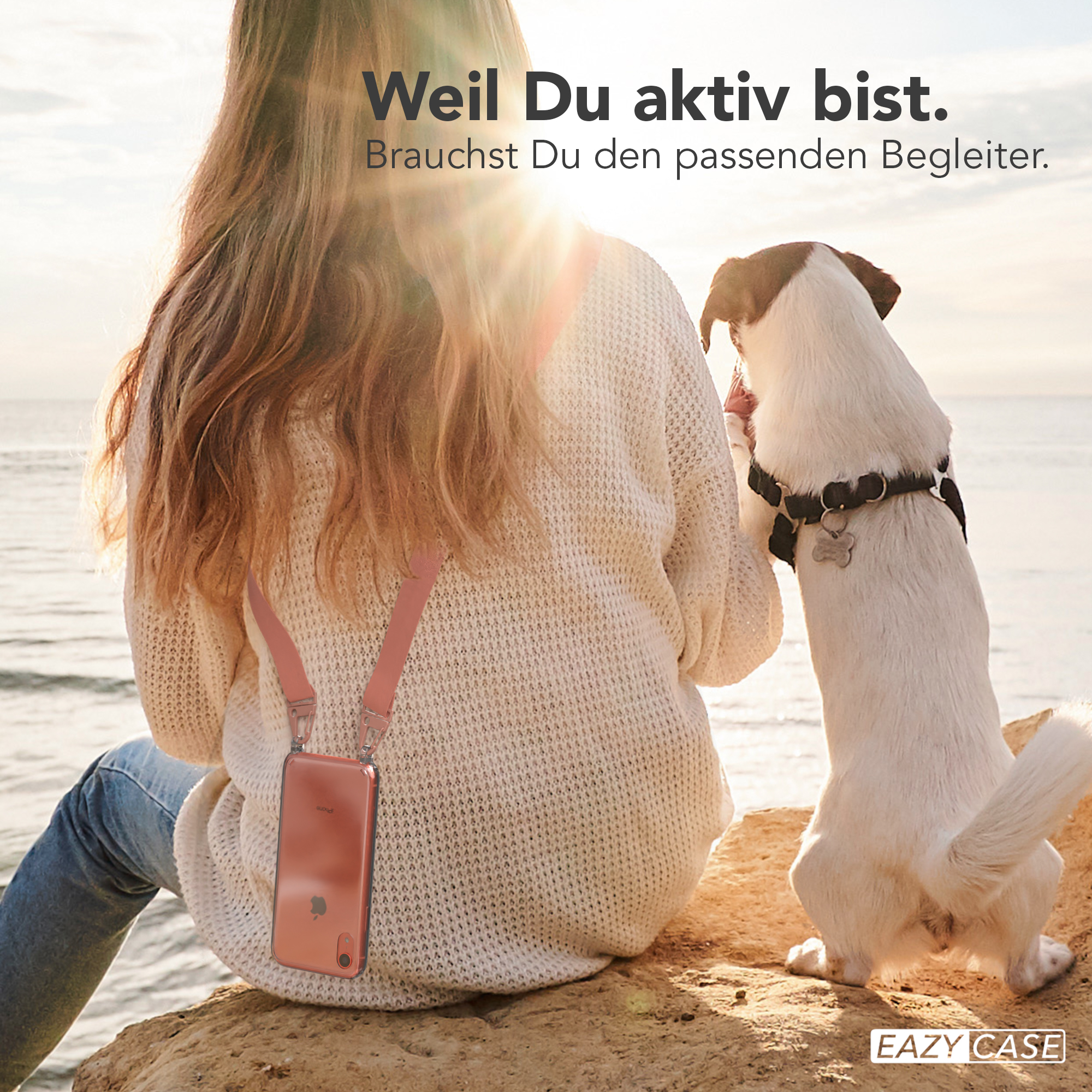 Frau mit Telefon und Gurt, Hund auf einem Felsen, sonnige Szene, mit Text: Weil du aktiv bist.