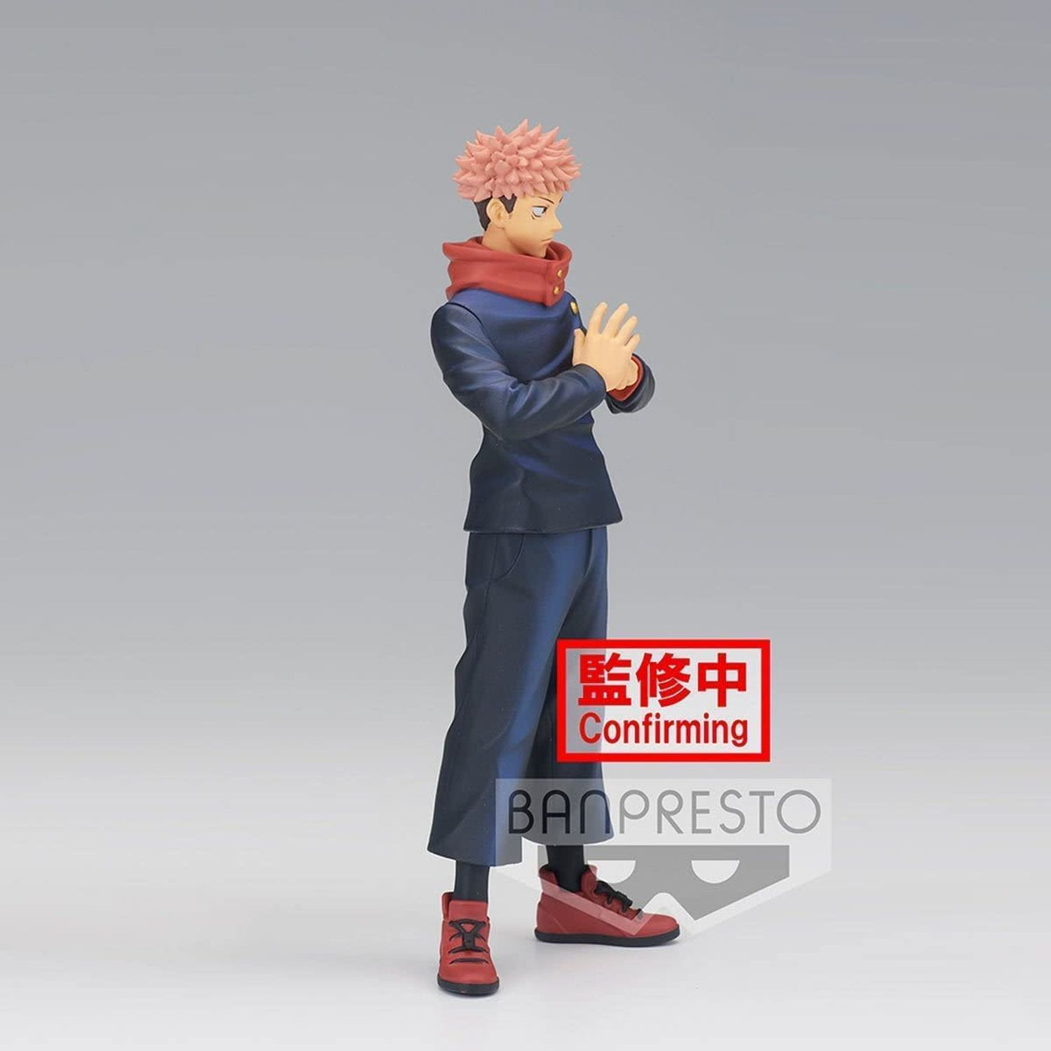 Figura de anime de un hombre con ropa azul y roja. Fondo gris.