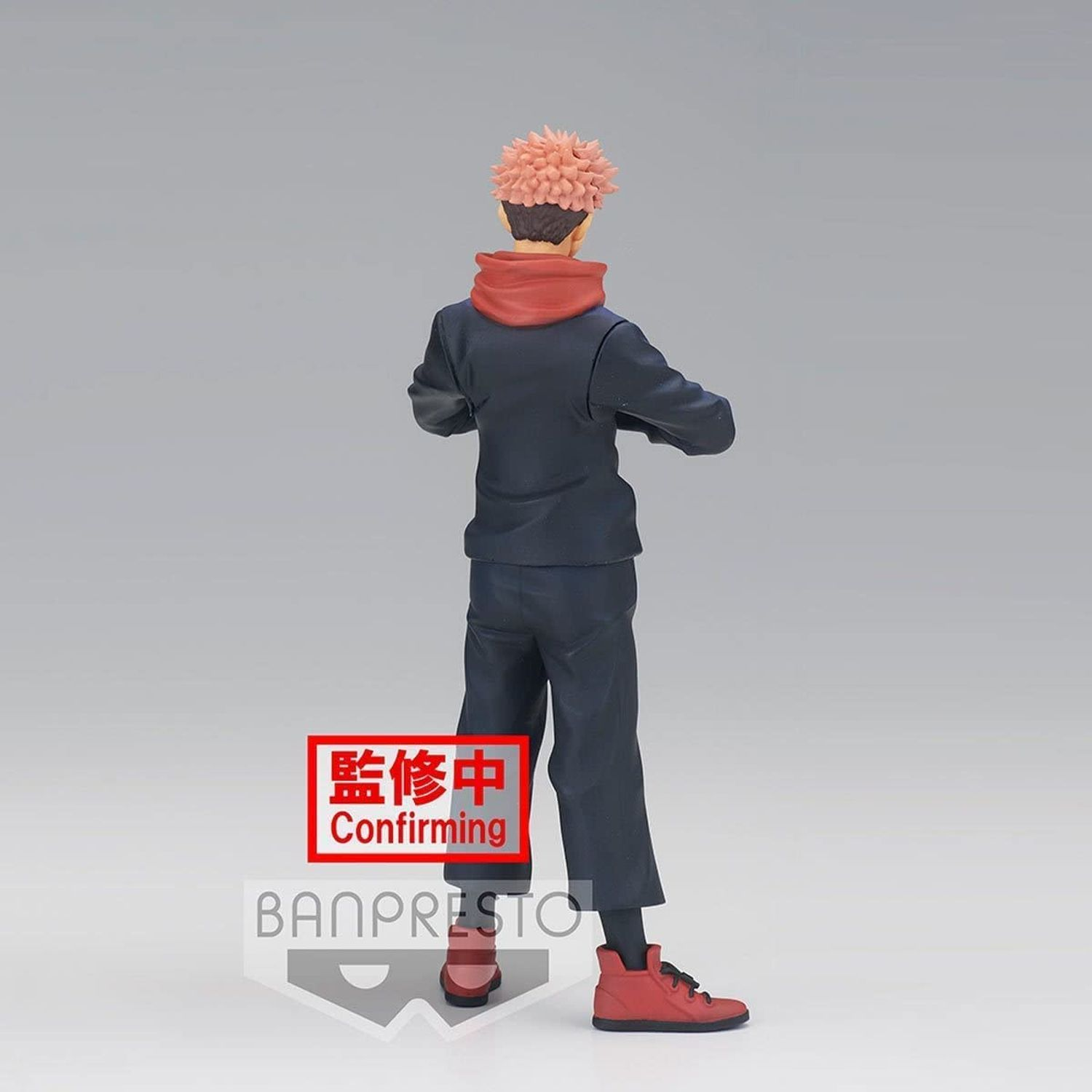 Vista trasera de una figura de anime con uniforme azul oscuro, pelo y zapatos rojos.